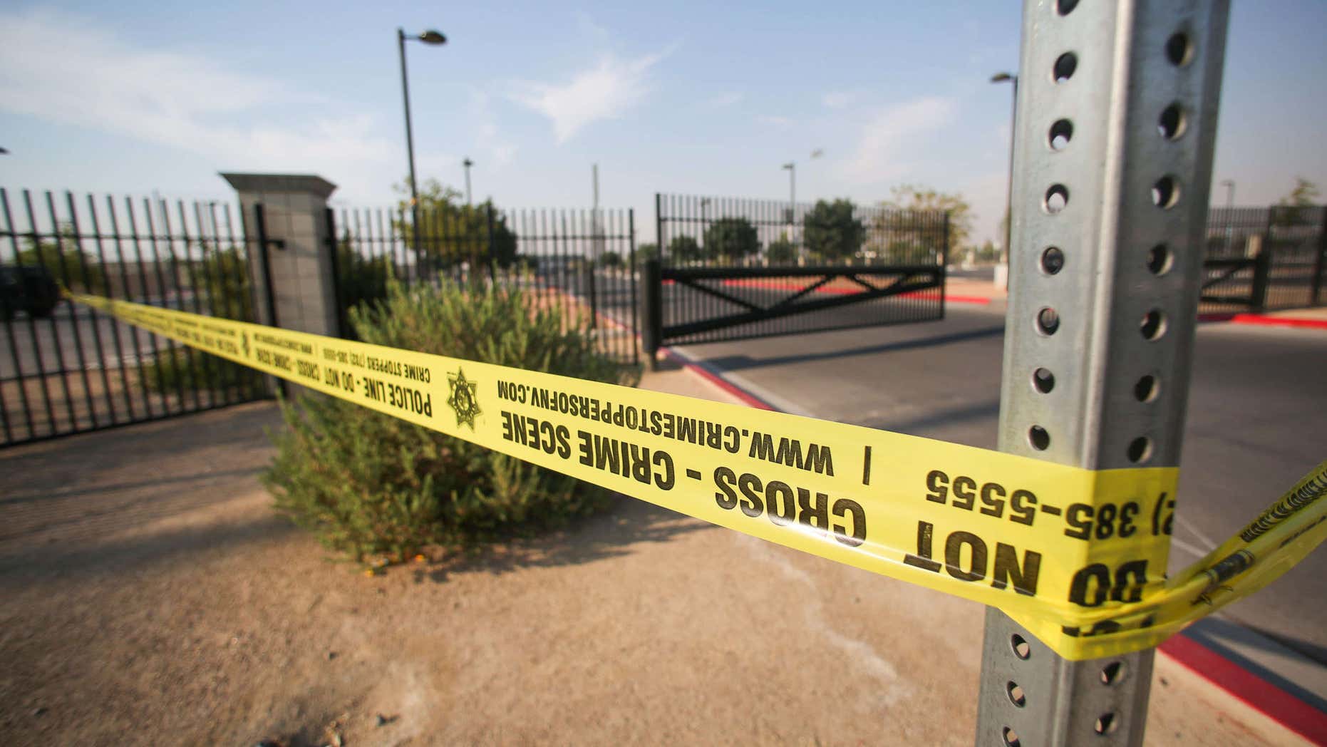 Police tape hangs at Gary Reese Freedom Park, where police say a shooting erupted when a man in a vehicle attempted to rob a group of people playing "Pokemon GO" early Monday, July 25, 2016, in Las Vegas.