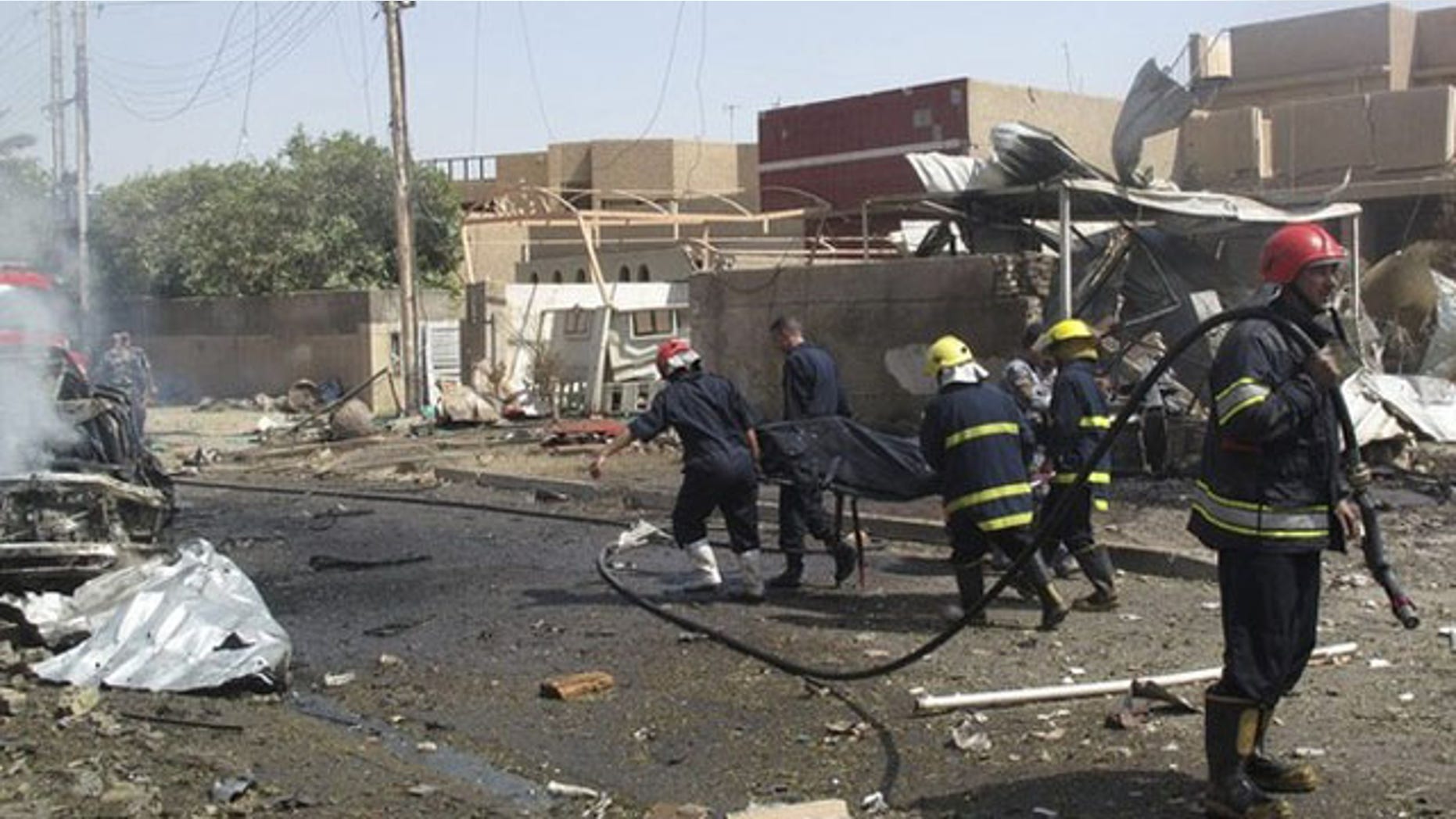 July 26: Rescue workers carry the body of a victim who was killed in a bomb attack in Baghdad. A homicide bomber killed at least four people on Monday in the attack that appeared to target the office of Dubai-based Al-Arabiya television in Baghdad, security officials said (Reuters).