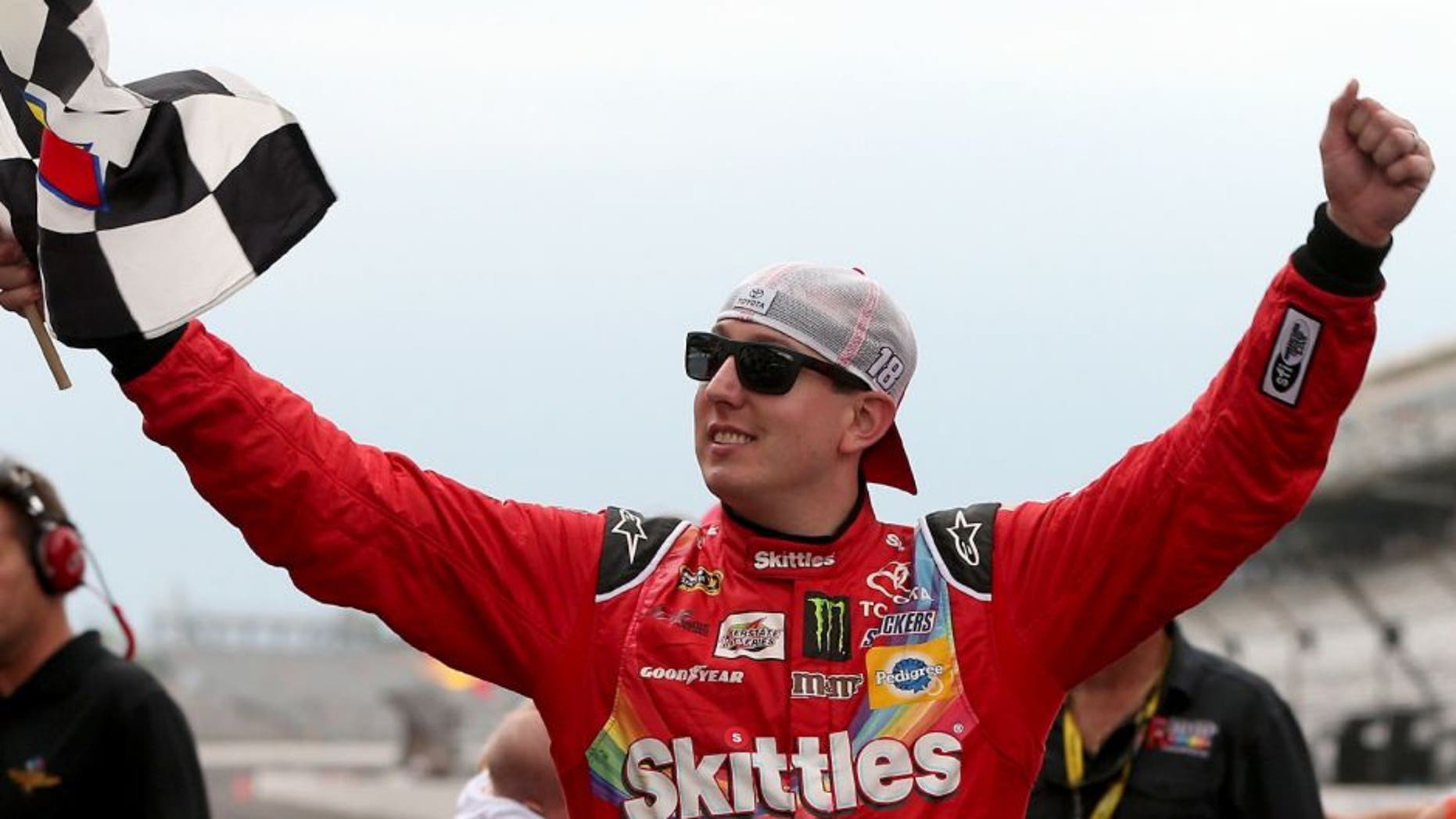 INDIANAPOLIS, IN - JULY 26: Kyle Busch, driver of the #18 Skittles Toyota, celebrates with the checkered flag after winning the NASCAR Sprint Cup Series Crown Royal Presents the Jeff Kyle 400 at the Brickyard at Indianapolis Motor Speedway on July 26, 2015 in Indianapolis, Indiana. (Photo by Brian Lawdermilk/Getty Images)