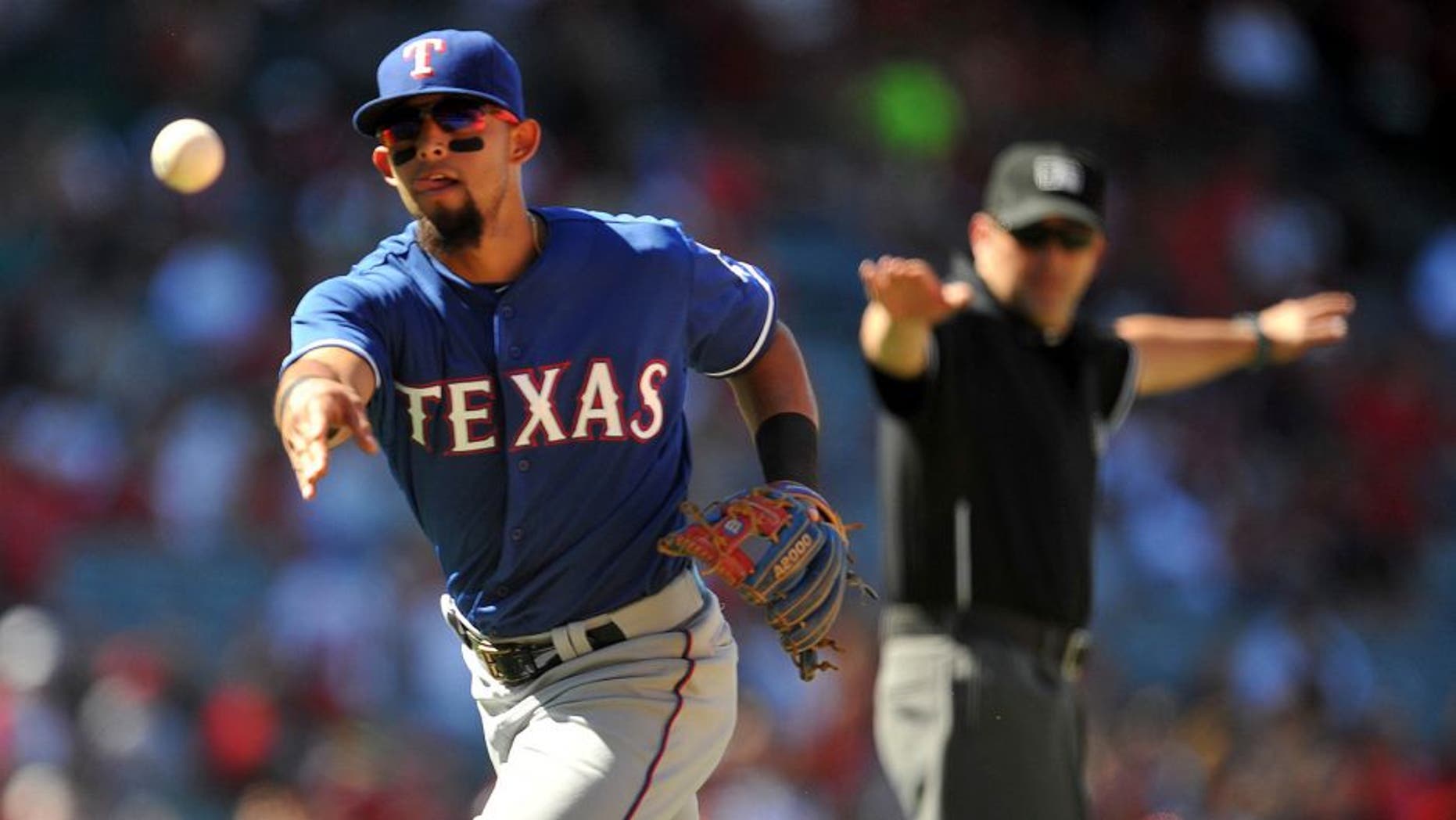 July 26, 2015; Anaheim, CA, USA; Texas Rangers second baseman Rougned Odor (12) tosses to first to complete an out in the eighth inning against the Los Angeles Angels at Angel Stadium of Anaheim. Mandatory Credit: Gary A. Vasquez-USA TODAY Sports