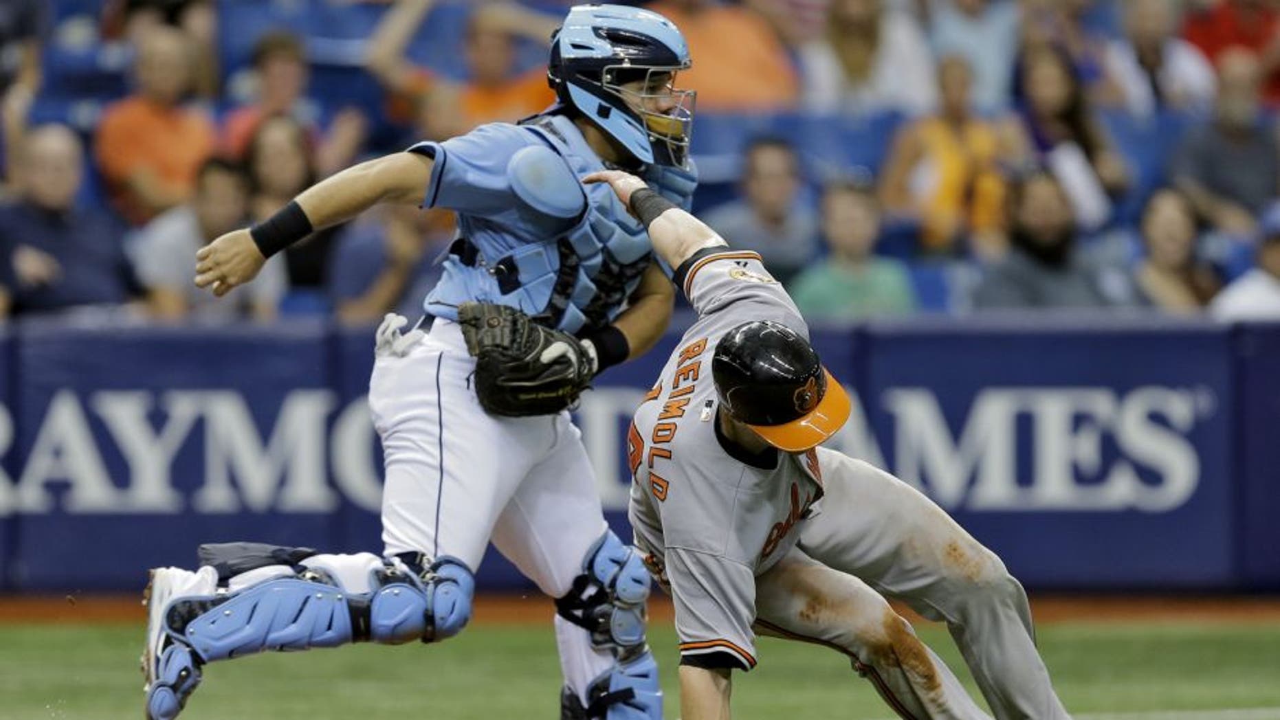 Tampa Bay Rays catcher Rene Rivera, right, tags out Baltimore Orioles' Nolan Reimold after getting caught in a rundown during the eighth inning of a baseball game Sunday, July 26, 2015, in St. Petersburg, Fla. Reimold missed the stop sign by third base coach Bobby Dickerson on a single by Jonathan Schoop off Rays pitcher Alex Colome. (AP Photo/Chris O'Meara)