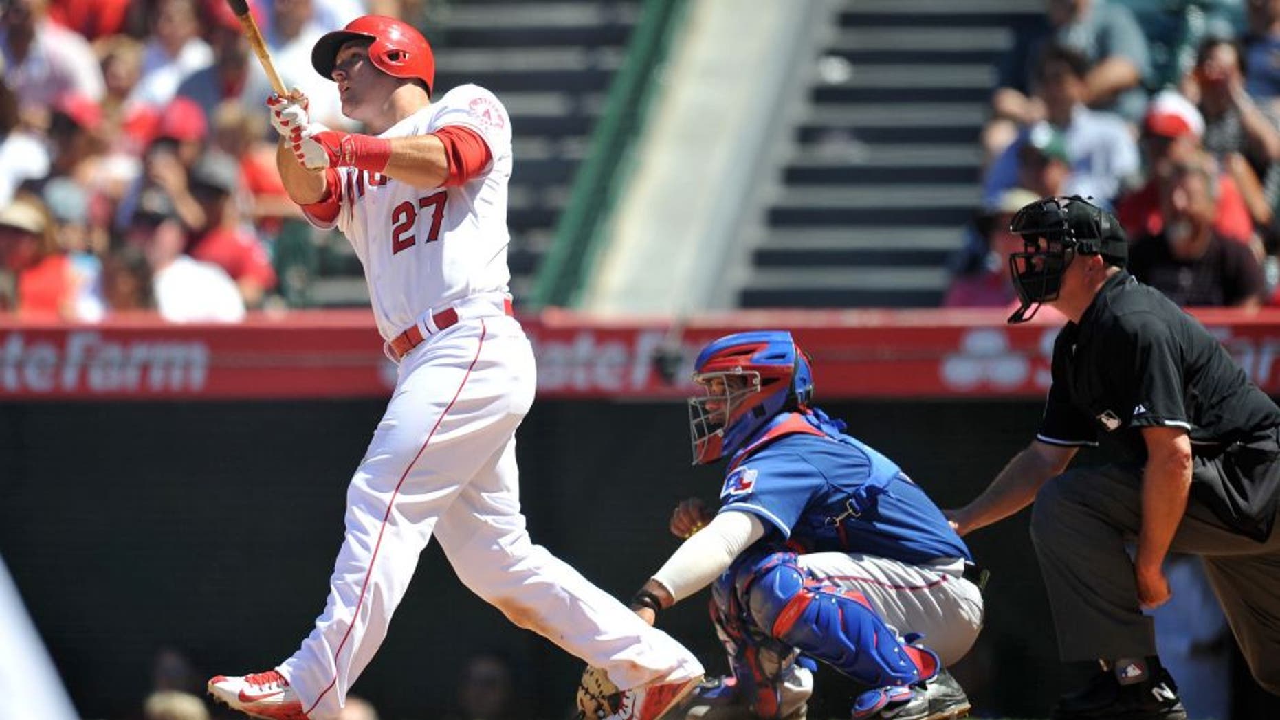 July 26, 2015; Anaheim, CA, USA; Los Angeles Angels center fielder Mike Trout (27) hits a grand slam home run in the sixth inning against the Texas Rangers at Angel Stadium of Anaheim. Mandatory Credit: Gary A. Vasquez-USA TODAY Sports