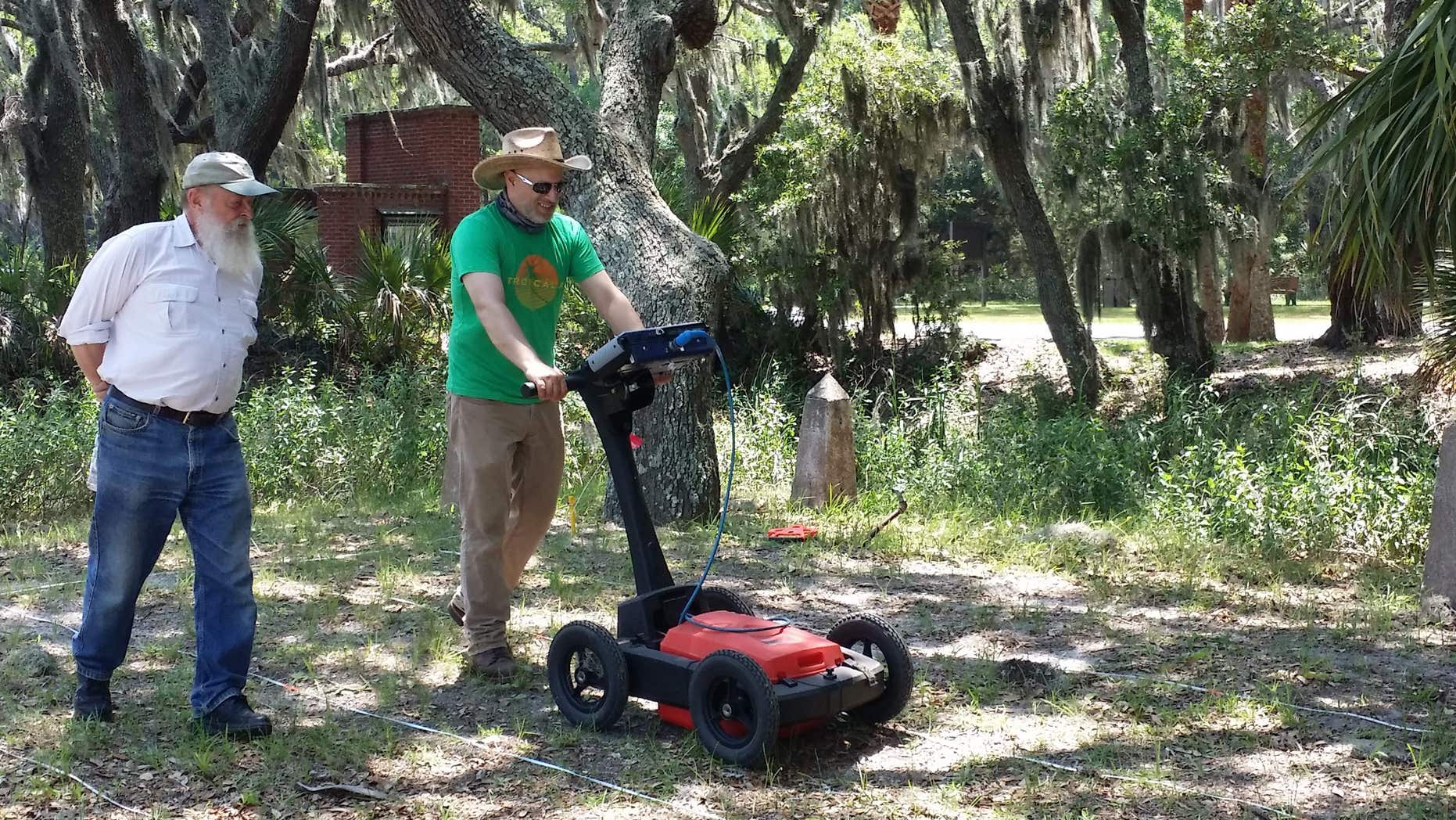 In this undated image provided by Amanda Thompson with the University of Georgia shows archeologists Chester DePratter, left, with the University of South Carolina and Victor Thompson, right, of the University of Georgia, running ground penetrating radar across a land grid.