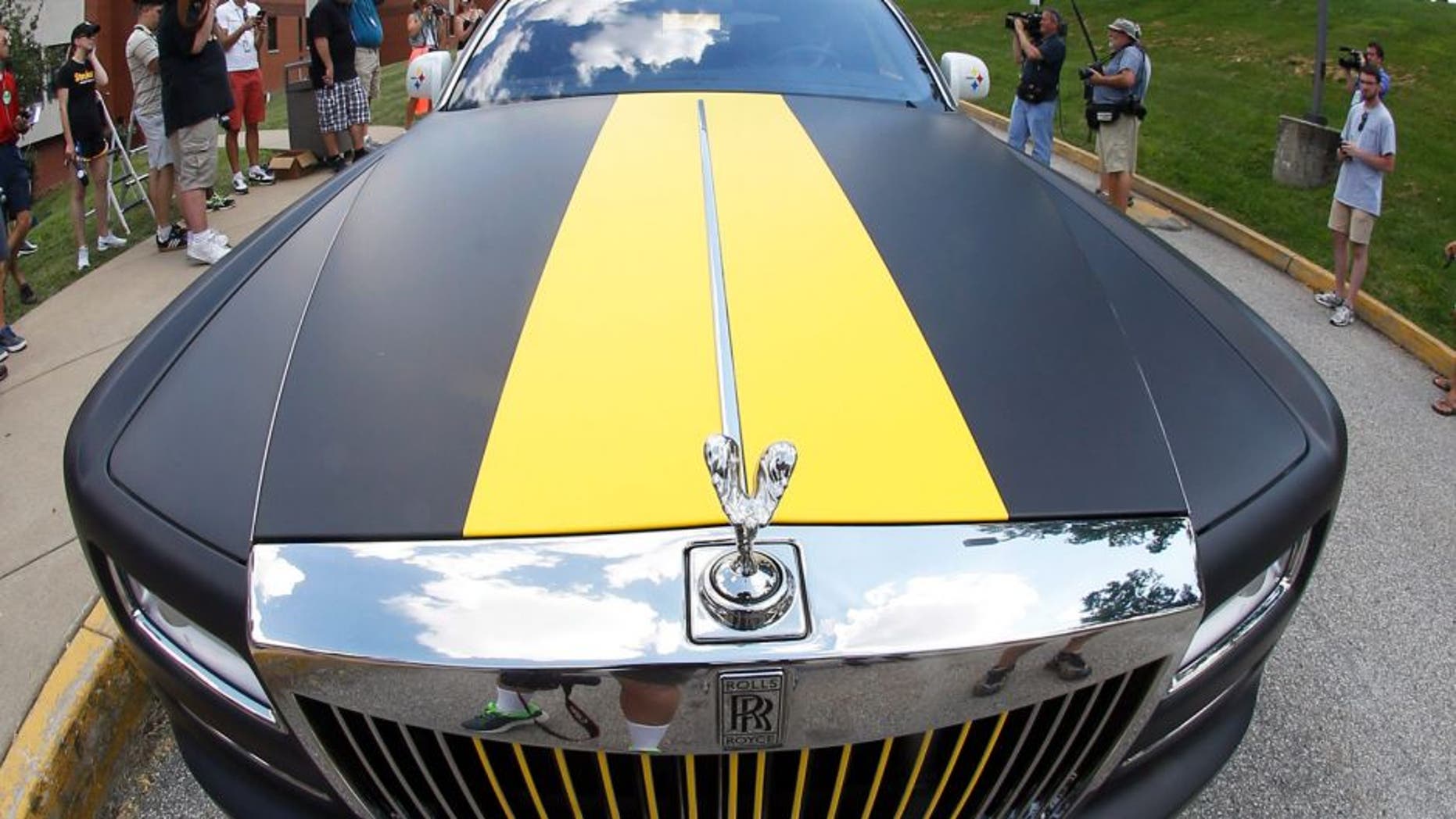 In this photo made with a fisheye lens, Pittsburgh Steelers wide receiver Antonio Brown arrives in a custom Steelers-themed Rolls Royce for NFL football training camp at the team's training facility in Latrobe, Pa., Saturday, July 25, 2015. (AP Photo/Keith Srakocic)