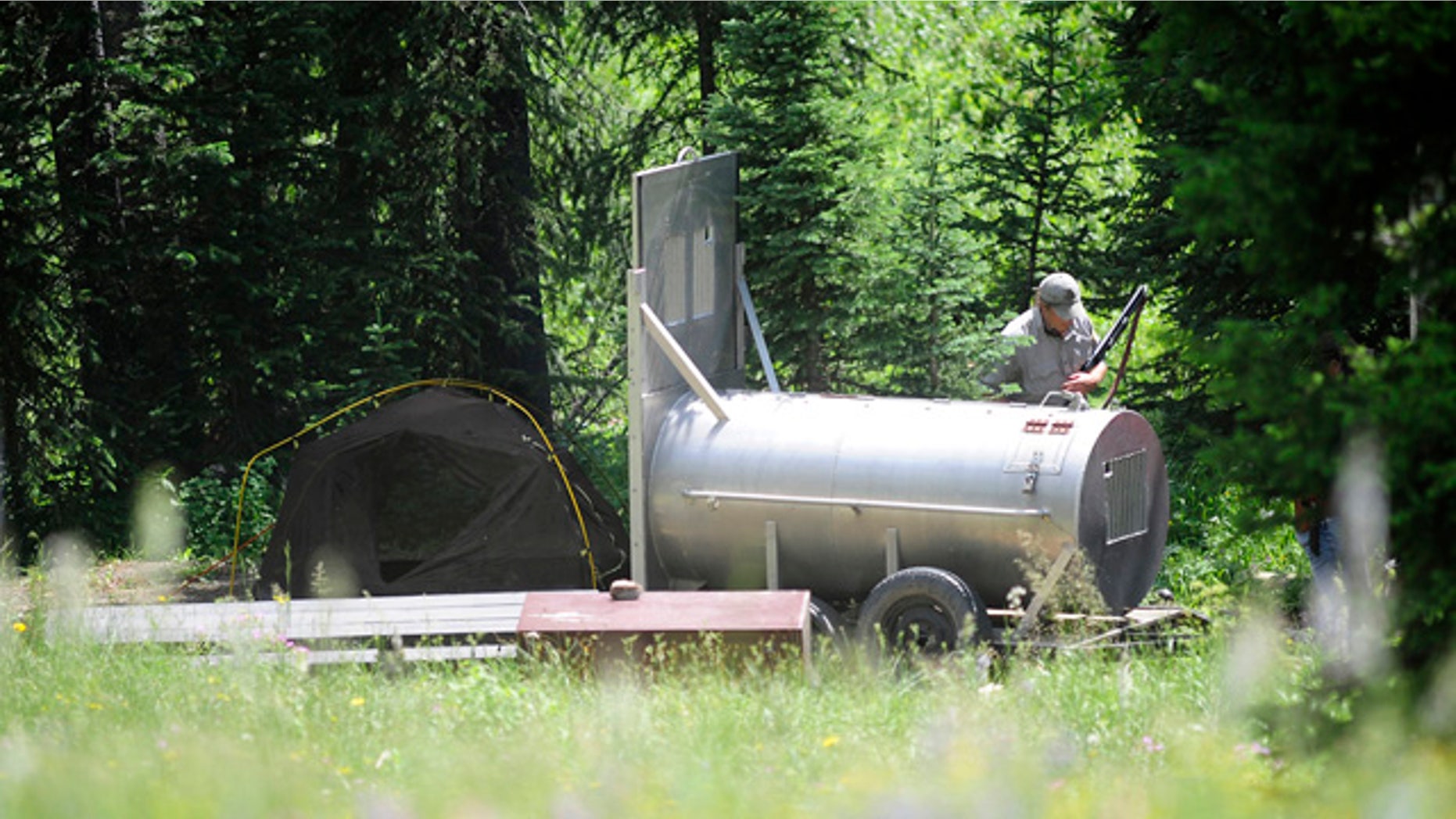 July 28: A FWP employee patrols the area where a man was killed by a bear in the Soda Butte campground in Cooke City, Mont.