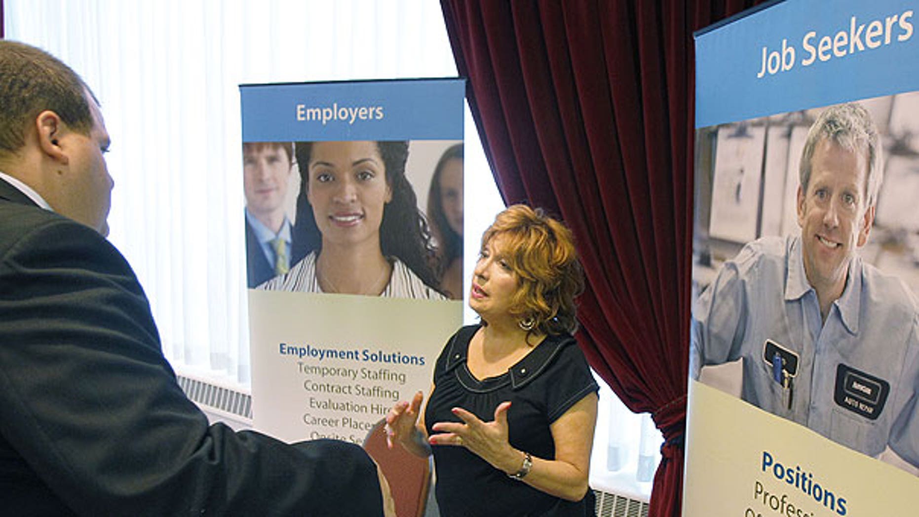 July 21, 2011: Donna Ciora, an employment specialist with Express Employment Professionals, right, talks with people attending the Pittsburgh Career Fair, in Pittsburgh.