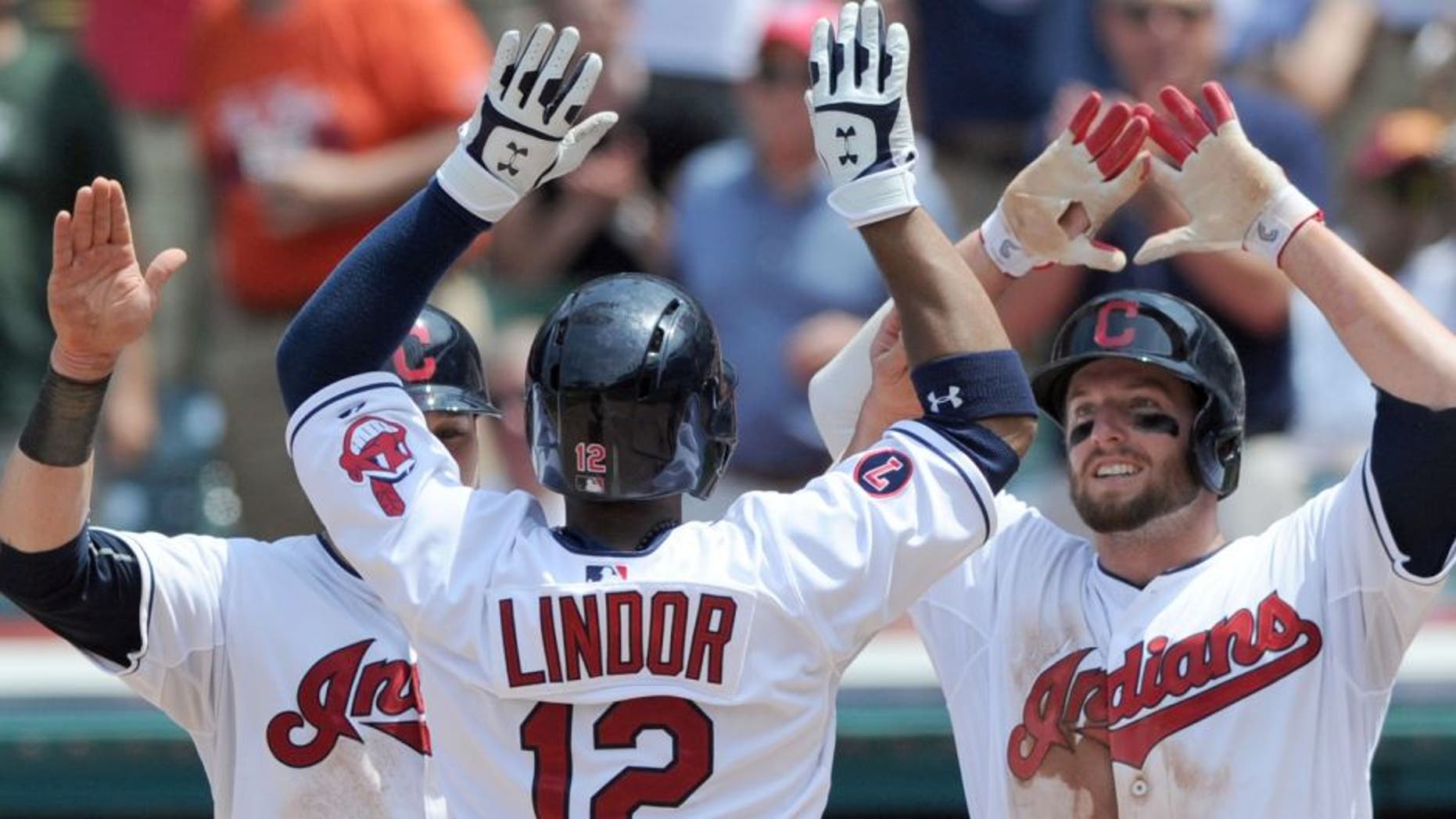 Jul 29, 2015; Cleveland, OH, USA; Cleveland Indians shortstop Francisco Lindor (12) celebrates with Indians left fielder Tyler Holt (13) and second baseman Jason Kipnis (22) after hitting a three-run home run during the sixth inning against the Kansas City Royals at Progressive Field.
