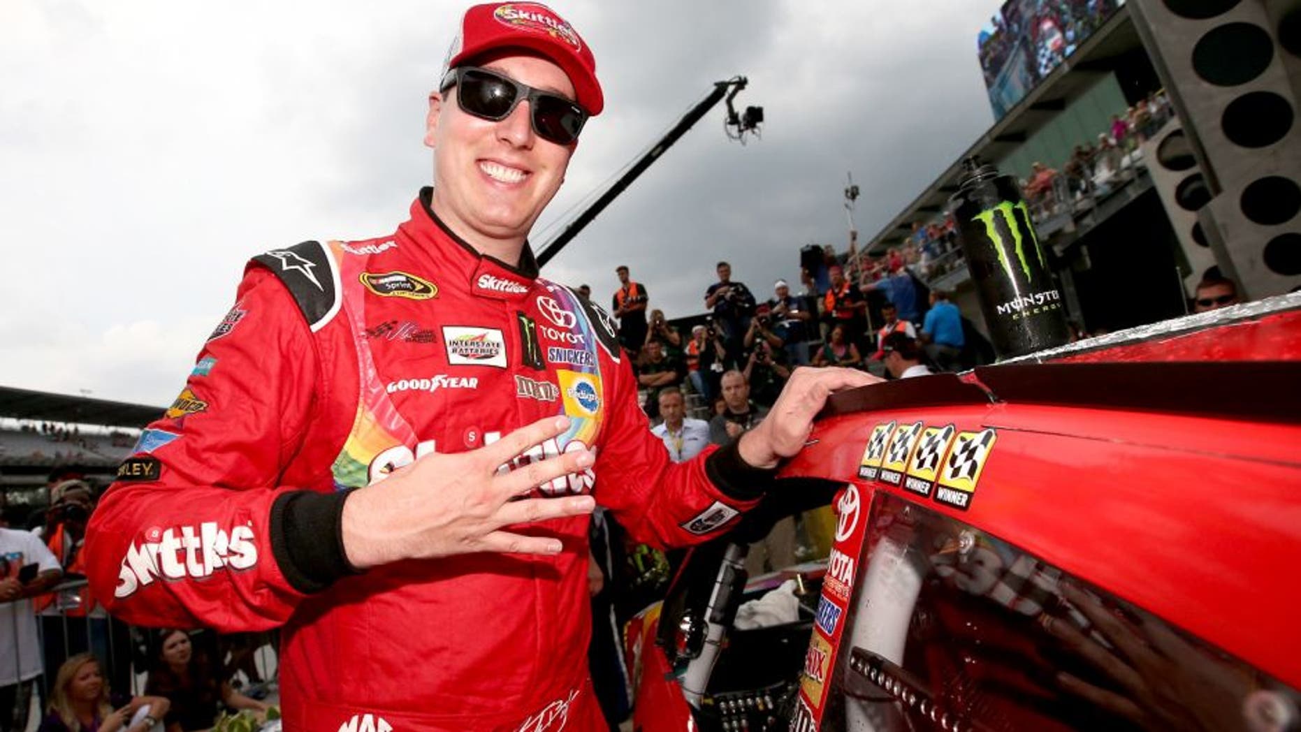 INDIANAPOLIS, IN - JULY 26: Kyle Busch, driver of the #18 Skittles Toyota, places the winner's decal in Victory Lane after winning the NASCAR Sprint Cup Series Crown Royal Presents the Jeff Kyle 400 at the Brickyard at Indianapolis Motor Speedway on July 26, 2015 in Indianapolis, Indiana. (Photo by Sean Gardner/NASCAR via Getty Images)