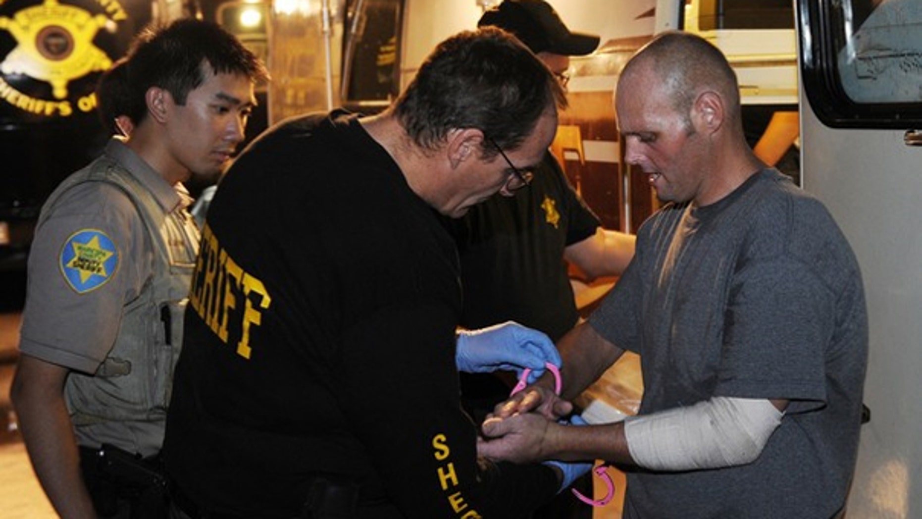July 29: An illegal immigrant is processed by Sheriff's Deputies working for Maricopa County sheriff Joe Arpaio, after an operational sweep in Phoenix. Protestors and police in riot gear clashed in several downtown locations with demonstrations against a new Arizona immigration law just hours after it went into effect. (Getty Images)