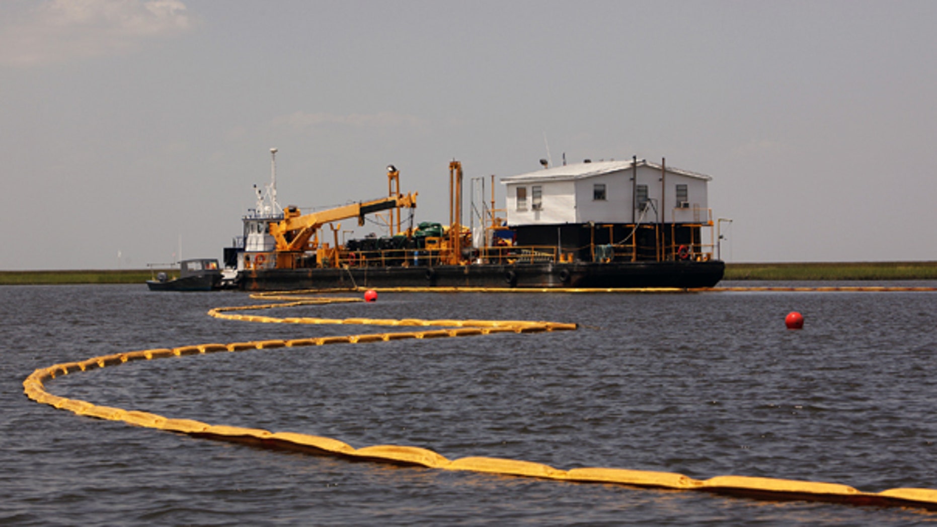 July 31: Oil containment boom is laid out in Treasure Pass, in waters near Yscloskey, La.