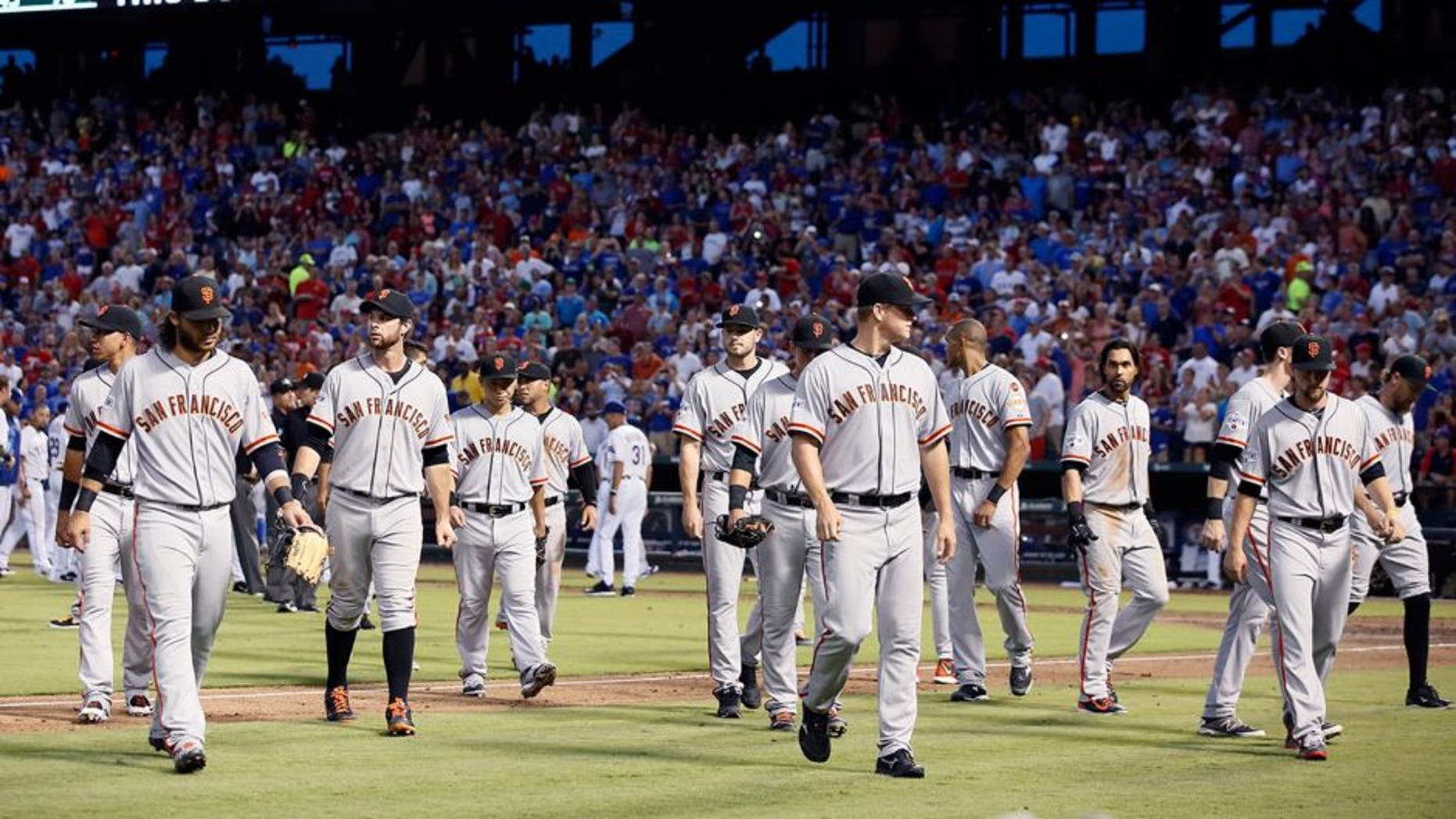 The San Francisco Giants return to their dugout after meeting the Texas Rangers on the field following a heated exchange between Giants pitcher Madison Bumgarner and members of the Rangers in the fourth inning of a baseball game Friday, July 31, 2015, in Arlington, Texas. (AP Photo/Tony Gutierrez)