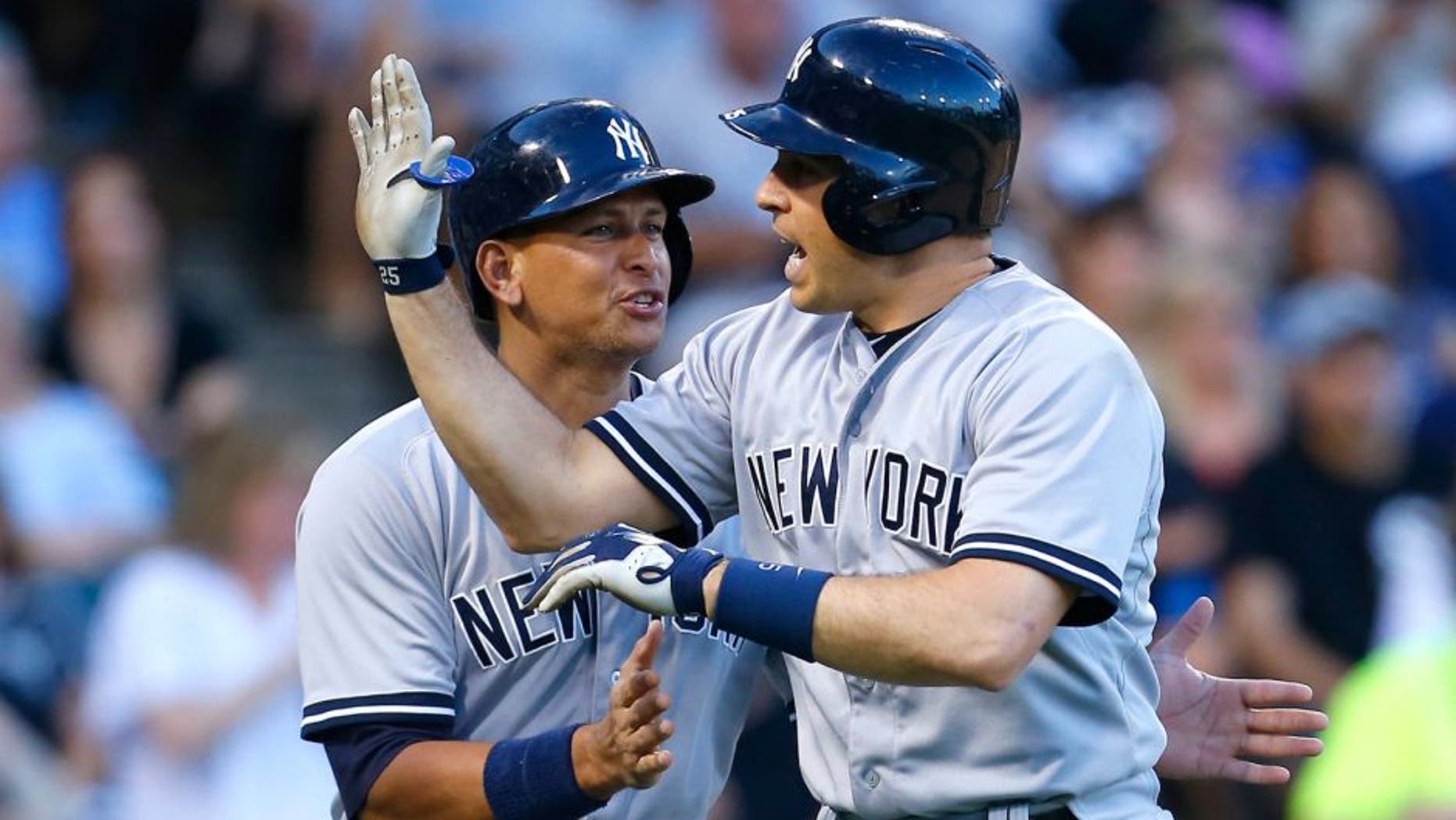 New York Yankees designated hitter Alex Rodriguez, left, celebrates with teammate Mark Teixeira after Teixeira's grand slam during the second inning of a baseball game against the Chicago White Sox in Chicago, Friday, July 31, 2015. (AP Photo/Jeff Haynes)