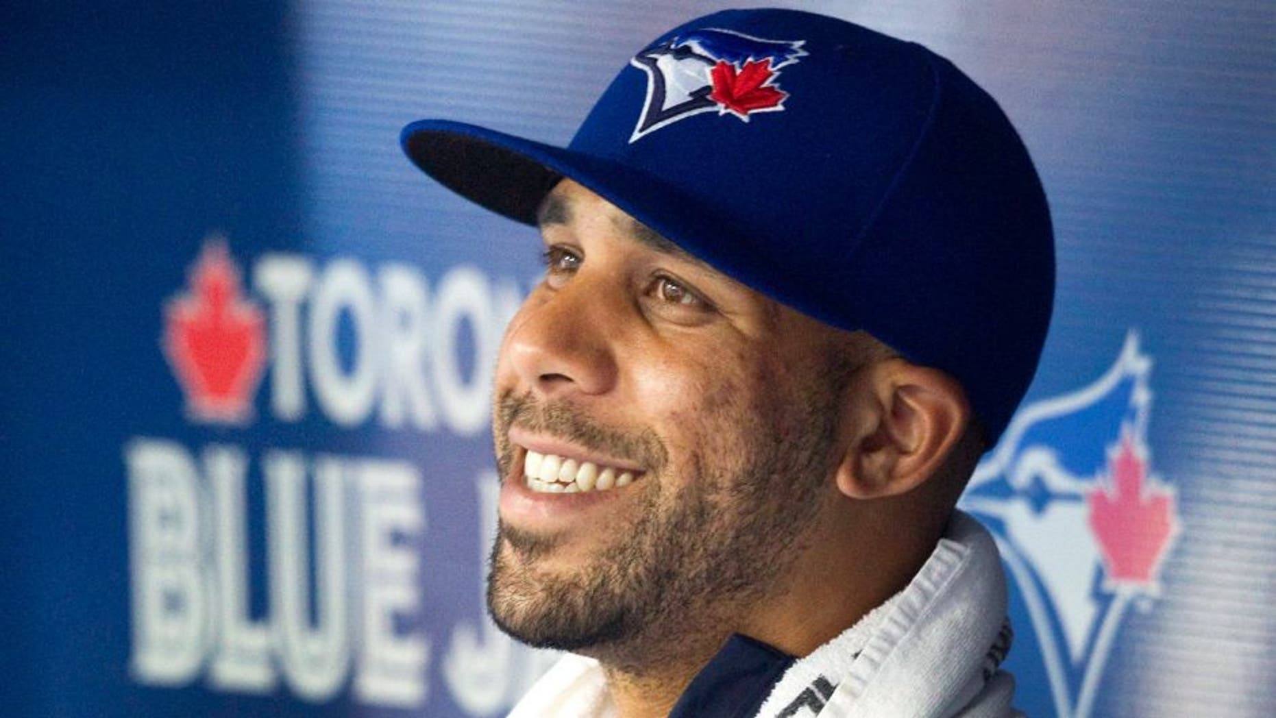 Toronto Blue Jays newly acquired starting pitcher David Price smiles in the dugout as his team plays the Kansas City Royals during the second inning of a baseball game, Friday, July 31, 2015 in Toronto. (Fred Thornhill/The Canadian Press via AP) MANDATORY CREDIT