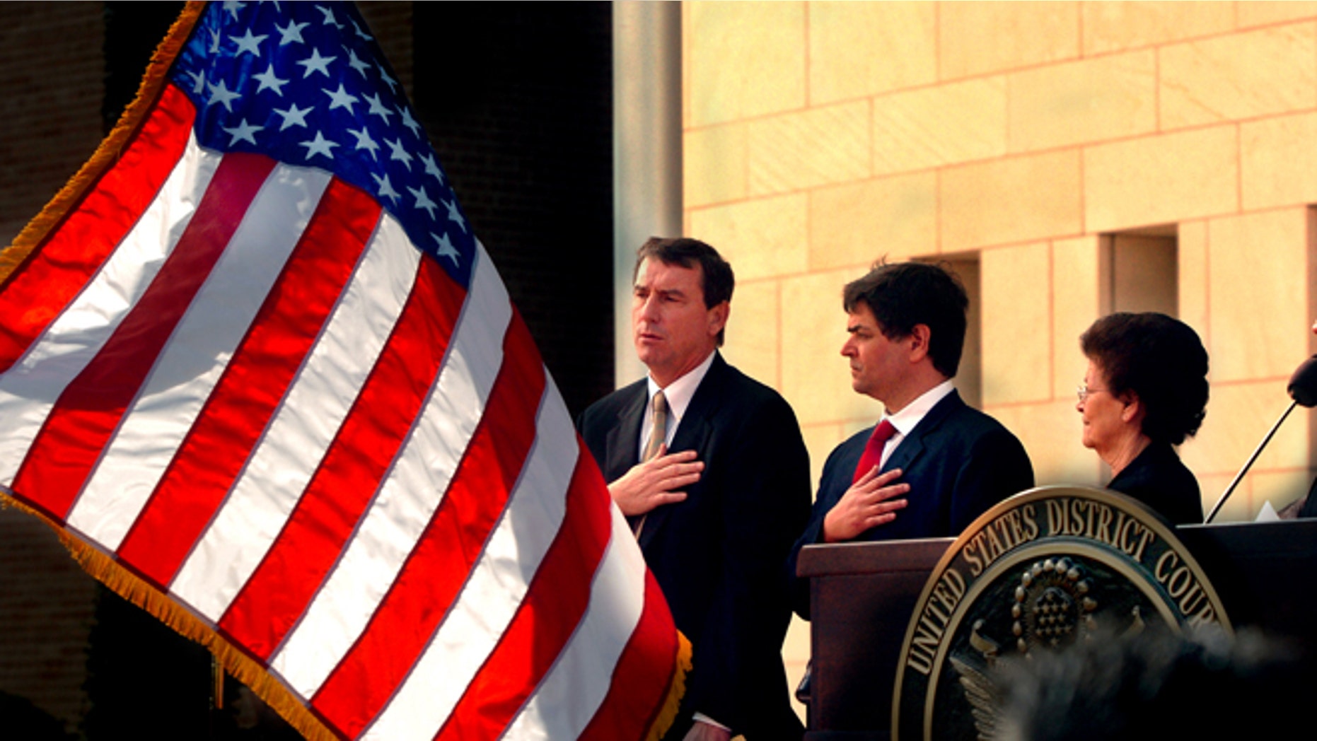 FILE- In this Nov. 14, 2005, file photo, U.S. Southern District Judge Andrew S. Hanen, left, joins with Filemon B. Vela, Jr. and Blanca Vela for the Pledge of Allegiance during the United States Courthouse naming ceremony in Brownsville, Texas. Hanen temporarily blocked President Barack Obamaâs executive action on immigration Monday, Feb. 16, 2015, giving a coalition of 26 states time to pursue a lawsuit that aims to permanently stop the orders. (AP Photo/The Brownsville Herald, Brad Doherty, File)