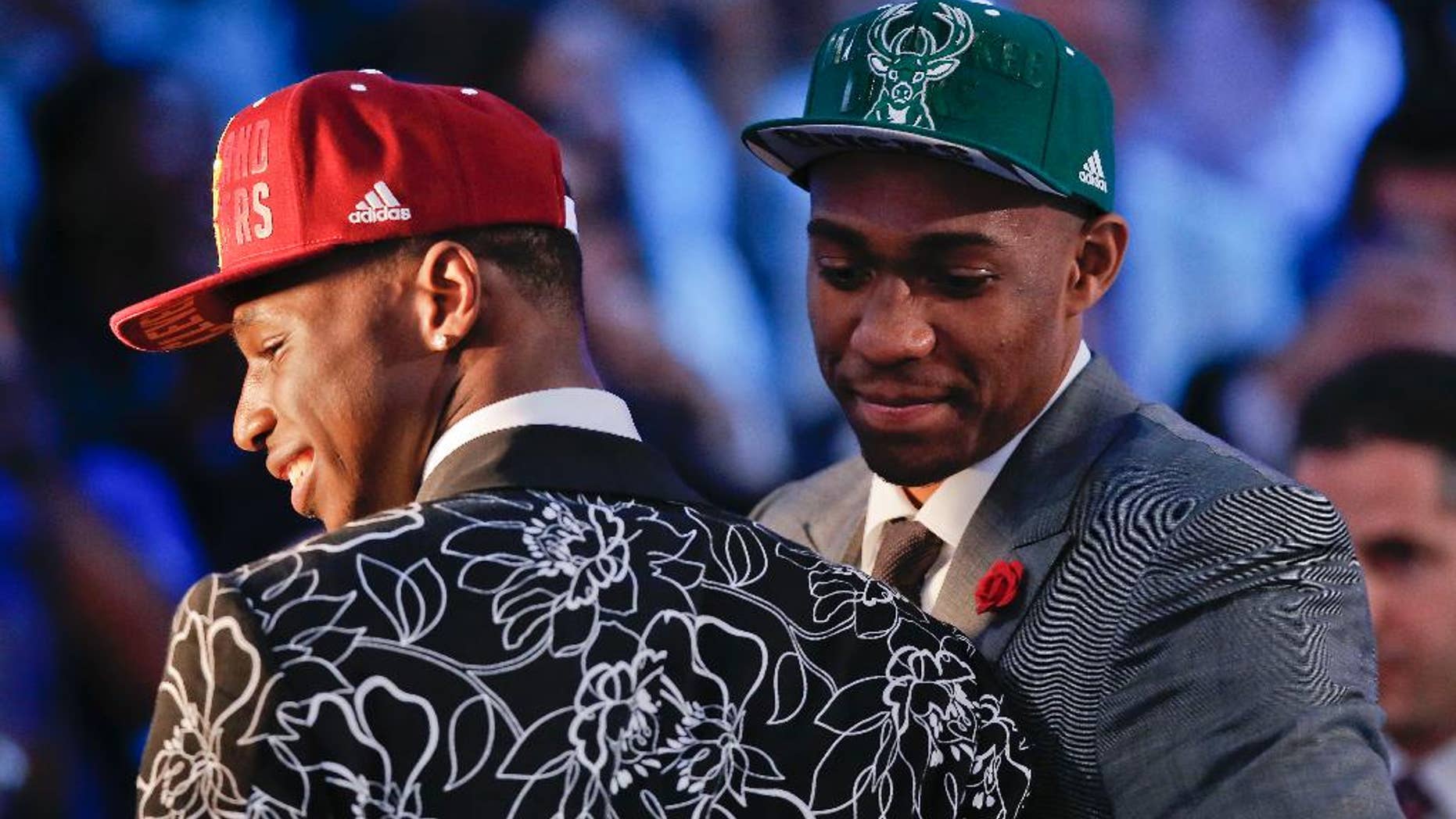 Andrew Wiggins, left, and Jabari Parker stop for television interviews after being selected as the top two picks in the 2014 NBA draft, Thursday, June 26, 2014, in New York. Wiggins was selected number one by the Cleveland Cavaliers and Parker was chosen number two by the Milwaukee Bucks. (AP Photo/Kathy Willens)