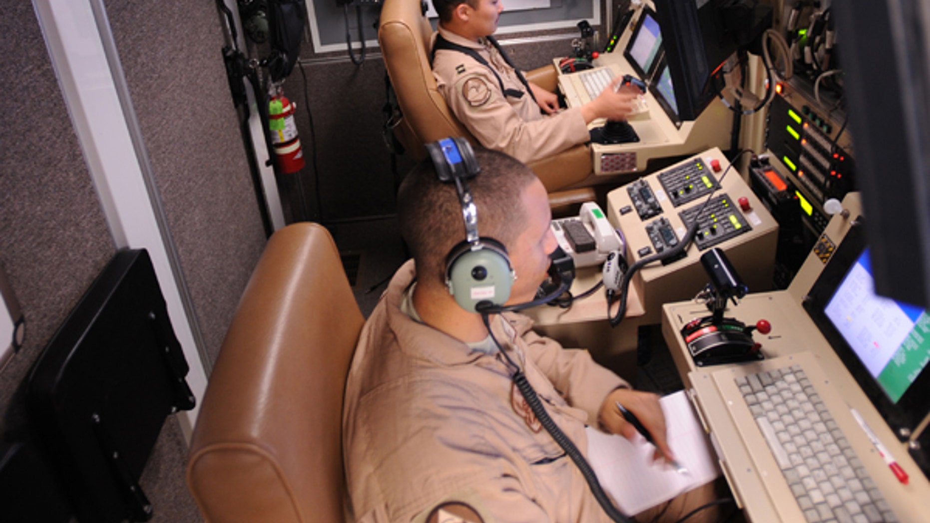 Capt. Ryan Jodoi, a UAV pilot, flies an MQ-9 Reaper while Airman 1st Class Patrick Snyder controls a full motion video camera at Kandahar Air Base, Afghanistan, March 13, 2009, in support of Operation Enduring Freedom. (U.S. Air Force photo by Staff Sgt. James L. Harper Jr.)