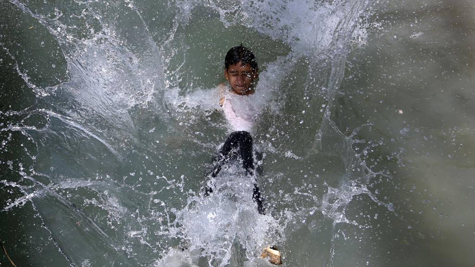 An Afghan teenager jumps into a canal on the outskirts of Kabul, Afghanistan on Wednesday, July 13, 2016. (AP Photo/Rahmat Gul)