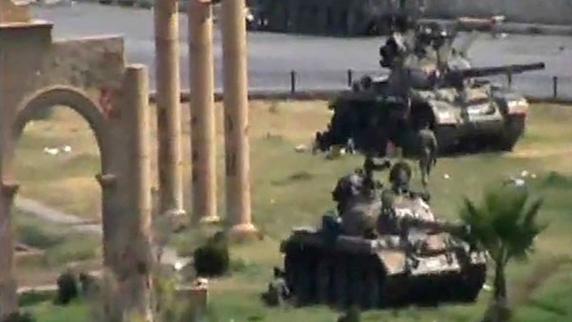 Aug. 1: In this image made from amateur video released by the so-called Shams News Network, a loosely organized anti-Assad group and accessed via The Associated Press Television News, military armored vehicles are seen in the central city of Hama, Syria.