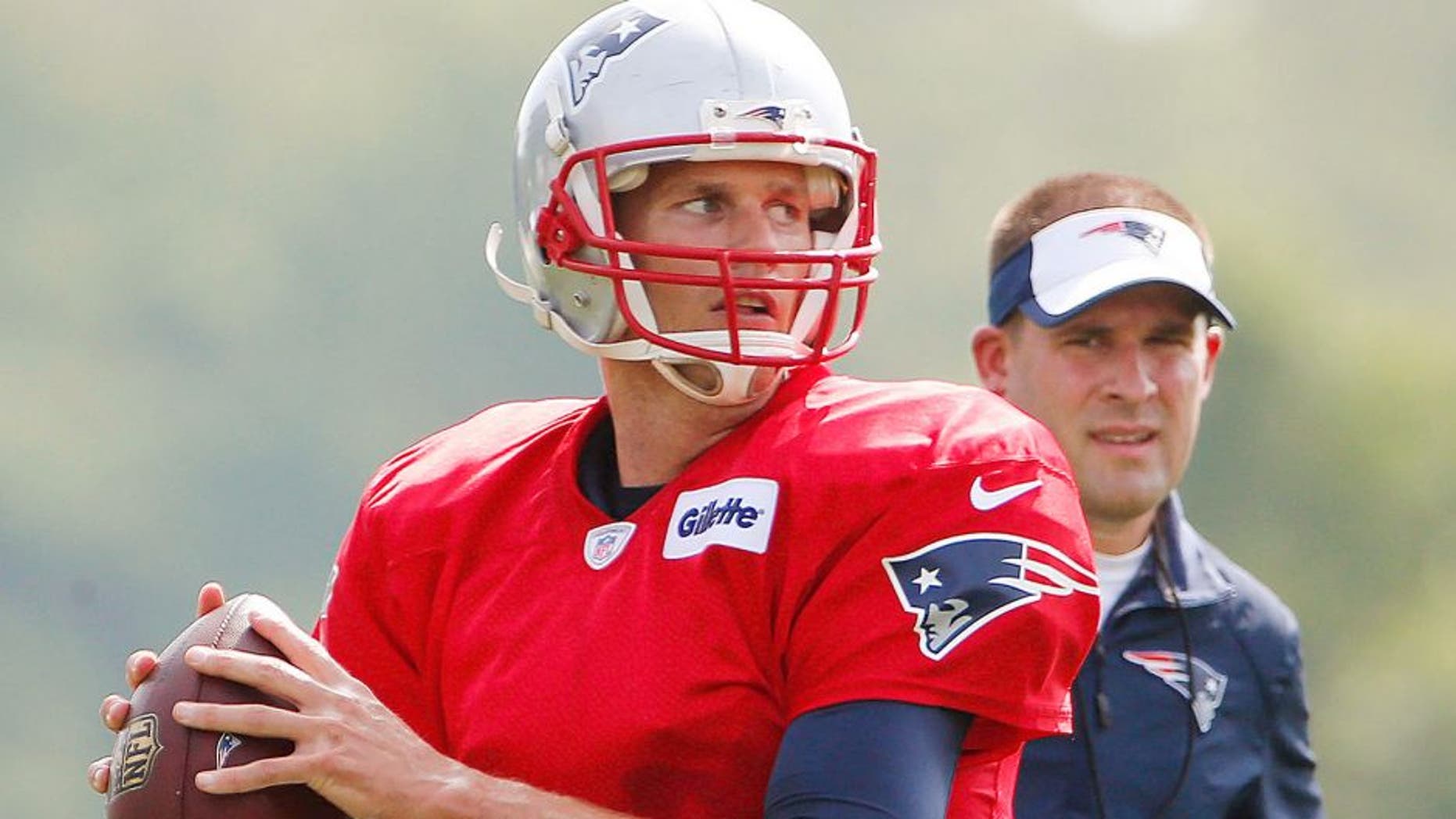 Jul 30, 2015; Foxborough, MA, USA; As offensive coordinator Josh McDaniels looks on, New England Patriots quarterback Tom Brady (12) throws during training camp at Gillette Stadium. Mandatory Credit: Winslow Townson-USA TODAY Sports