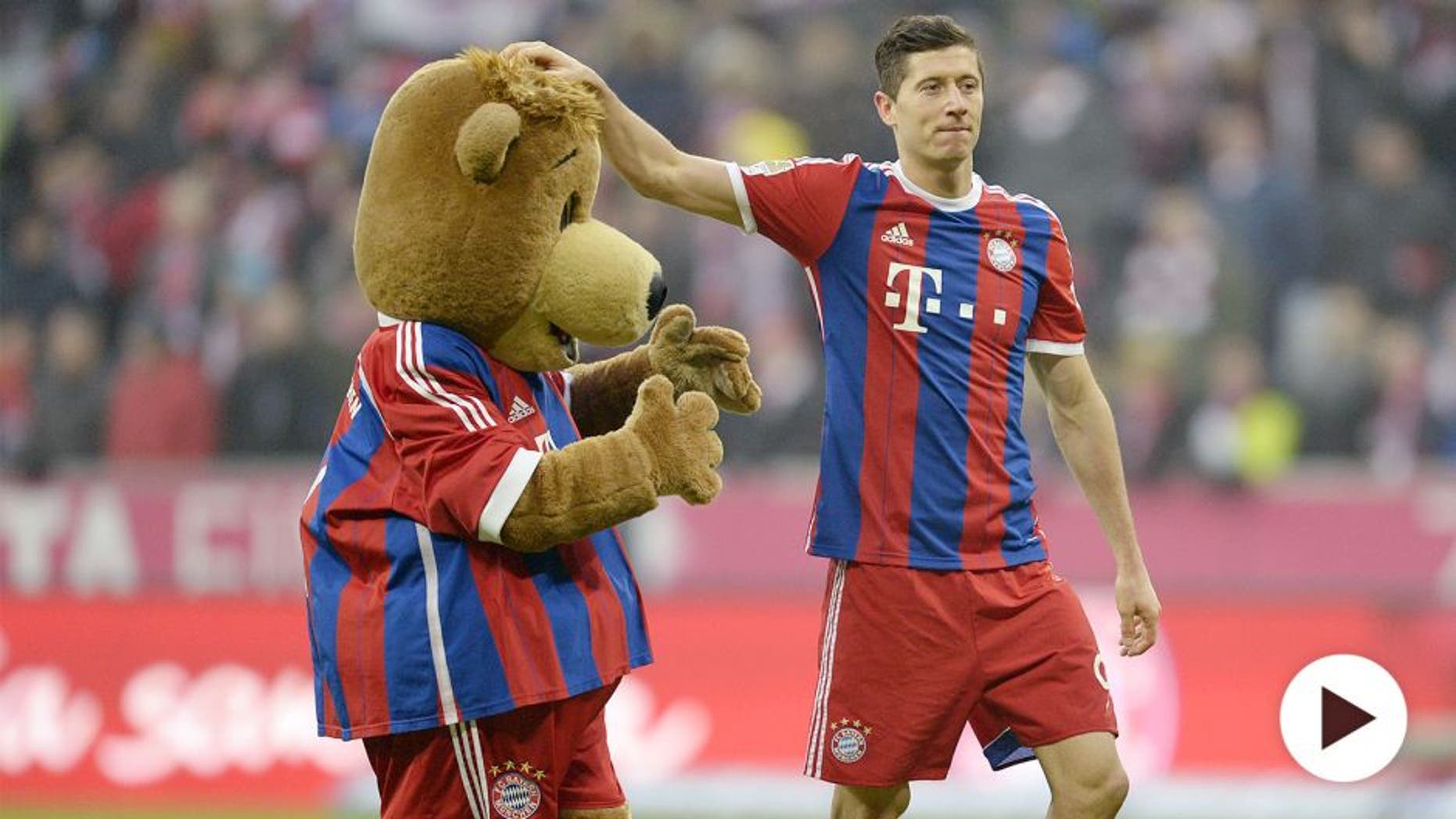 Bayern Munich's Polish striker Robert Lewandowski plays with the maskot after the German first division Bundesliga football match FC Bayern Munich vs Hamburger SV at the Allianz Arena in Munich, southern Germany, on February 14, 2015. AFP PHOTO / CHRISTOF STACHE RESTRICTIONS - DFL RULES TO LIMIT THE ONLINE USAGE DURING MATCH TIME TO 15 PICTURES PER MATCH. FOR FURTHER QUERIES PLEASE CONTACT DFL DIRECTLY AT + 49 69 650050 (Photo credit should read CHRISTOF STACHE/AFP/Getty Images)