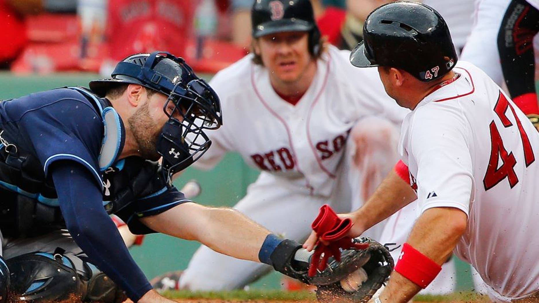 Boston Red Sox's Travis Shaw slides safely into home around the tag of Tampa Bay Rays catcher Curt Casali during the sixth inning of a baseball game at Fenway Park in Boston Saturday, Aug. 1, 2015. (AP Photo/Winslow Townson)