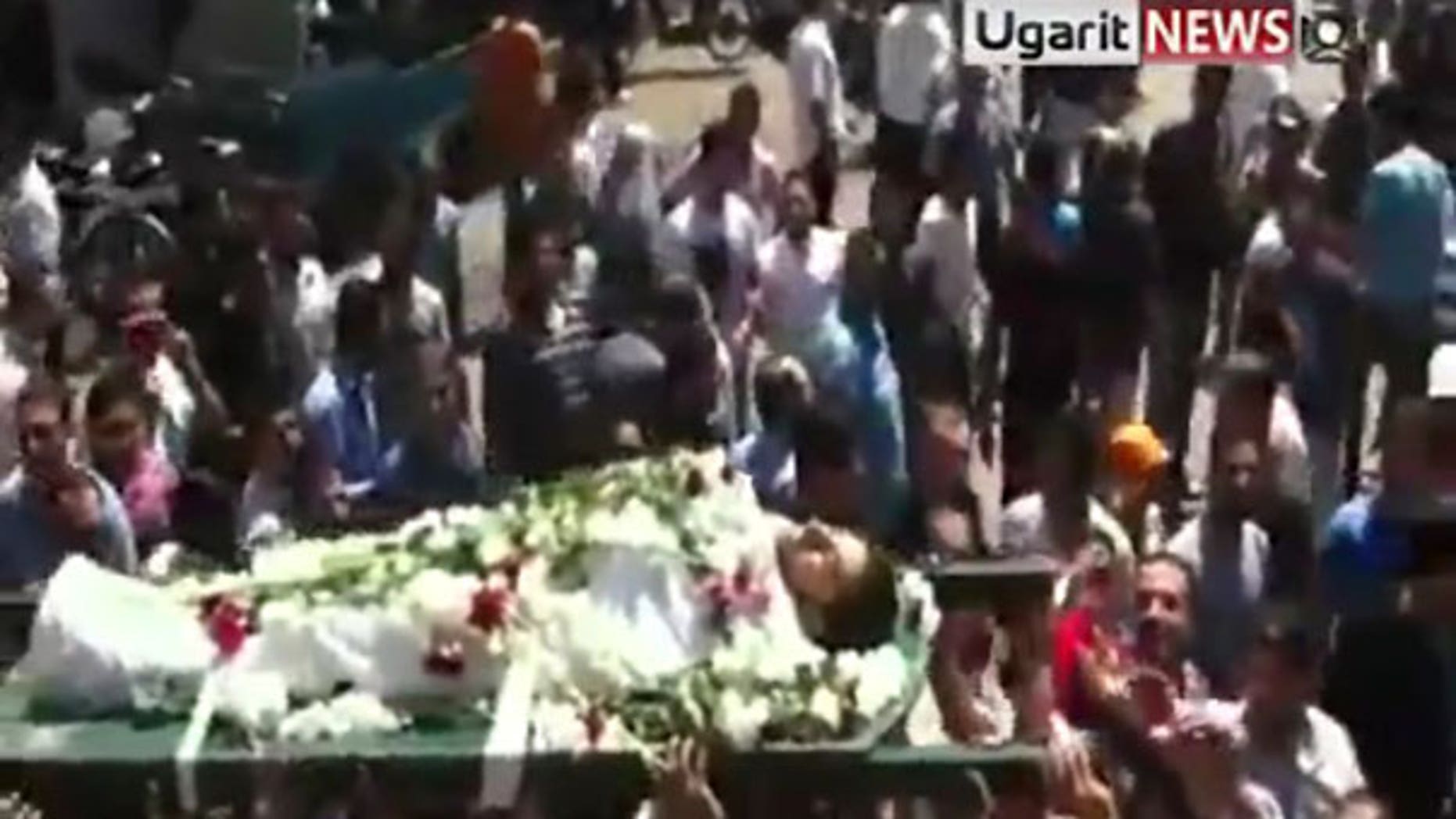 Aug. 2: In this image made from amateur video released by Ugarit News and accessed via The Associated Press Television News, mourners carry the body of a man during a funeral ceremony in the city of Homs, Syria. After killing scores of people in two days, Syrian troops tightened their siege on the city of Hama Tuesday by taking up positions near homes and sending residents fleeing for their lives.