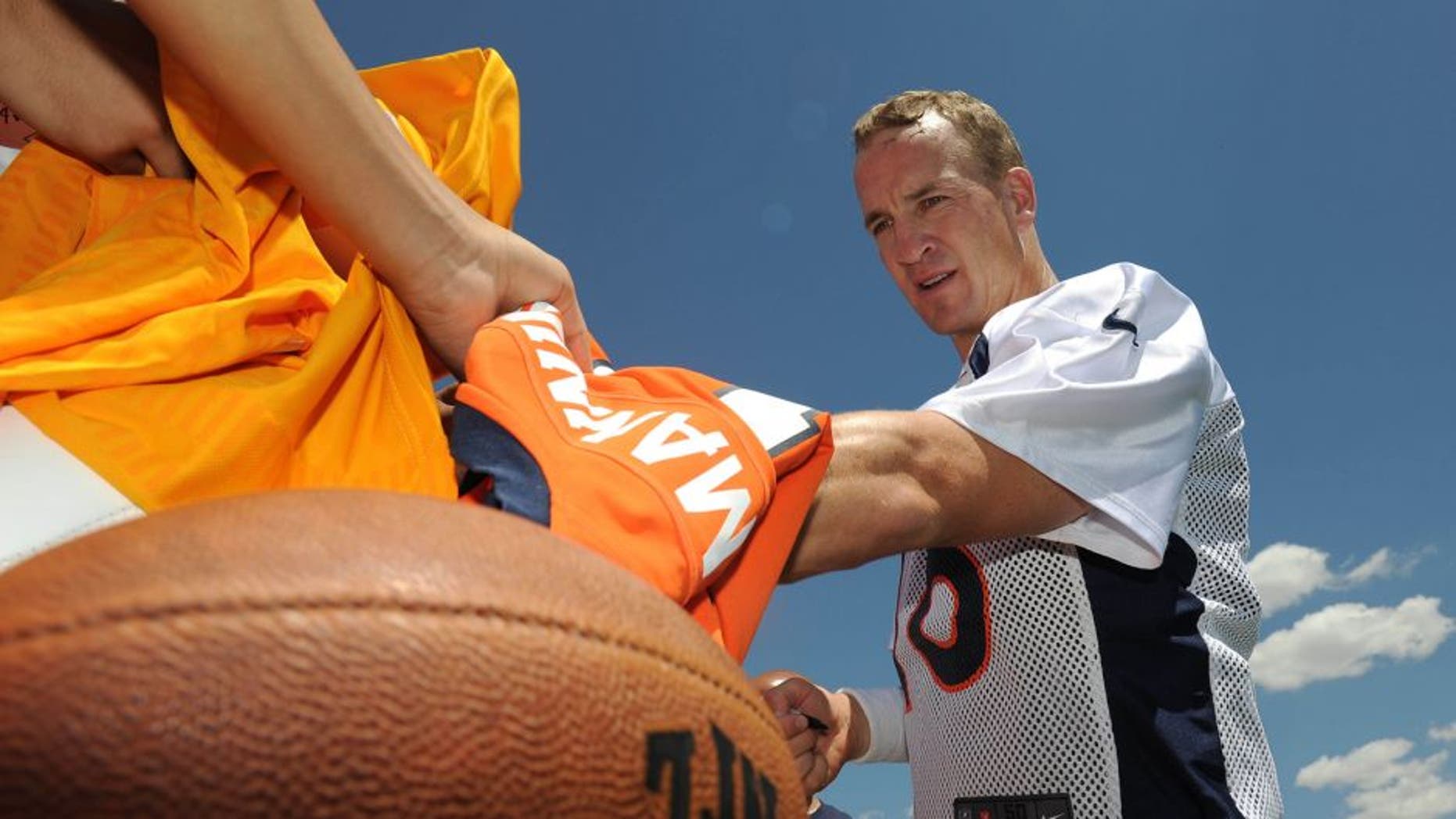 Jul 31, 2015; Englewood, CO, USA; Denver Broncos quarterback Peyton Manning (18) signs autographs following training camp activities at the UCHealth Training Center. Mandatory Credit: Ron Chenoy-USA TODAY Sports