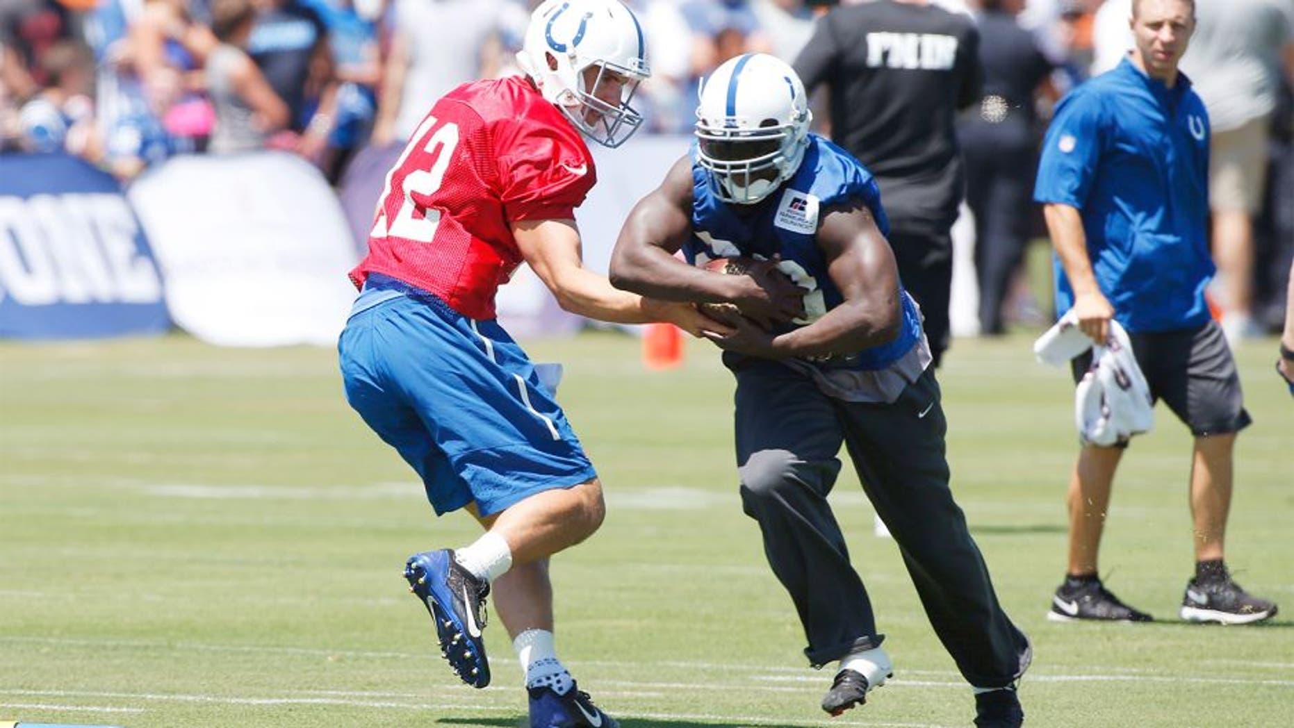 Aug 2, 2015; Anderson, IN, USA; Indianapolis Colts quarterback Andrew Luck (12) hands the ball off to running back Frank Gore (23) during training camp at Anderson University. Mandatory Credit: Brian Spurlock-USA TODAY Sports