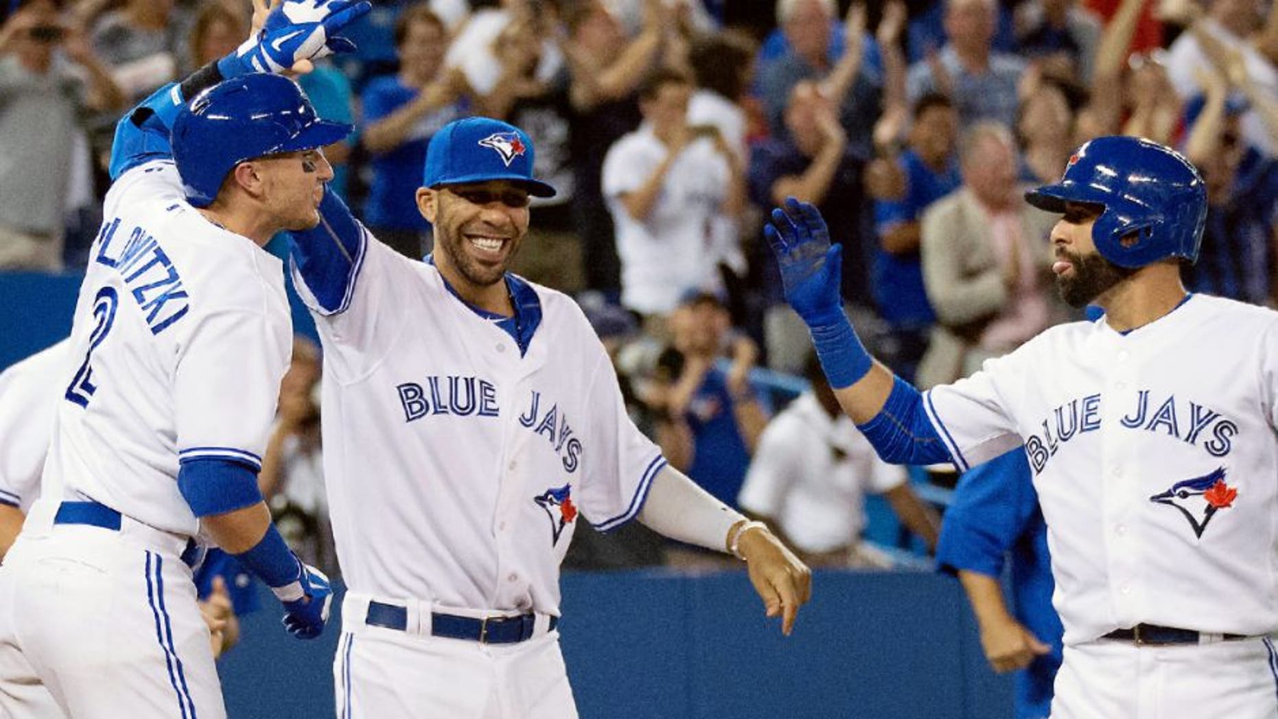 Jul 31, 2015; Toronto, Ontario, CAN; Toronto Blue Jays shortstop Troy Tulowitzki (2) and starting pitcher David Price (14) and right fielder Jose Bautista (19) celebrate the win during the eleventh inning in a game against the Kansas City Royals at Rogers Centre. The Toronto Blue Jays won 7-6. Mandatory Credit: Nick Turchiaro-USA TODAY Sports