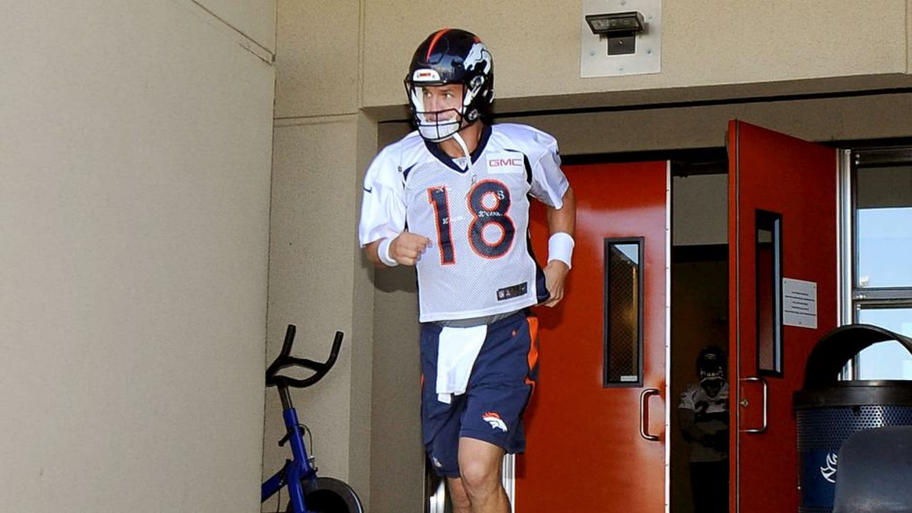 Jul 31, 2015; Englewood, CO, USA; Denver Broncos quarterback Peyton Manning (18) runs out of the locker room before the start of training camp at the UCHealth Training Center. Mandatory Credit: Ron Chenoy-USA TODAY Sports