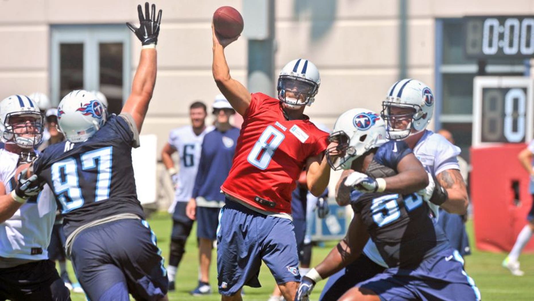 Jul 31, 2015; Nashville, TN, USA; Tennessee Titans quarterback Marcus Mariota (8) passes against Titans defensive lineman Karl Klug (97) during his first day of training camp at Saint Thomas Sports Park. Mandatory Credit: Jim Brown-USA TODAY Sports