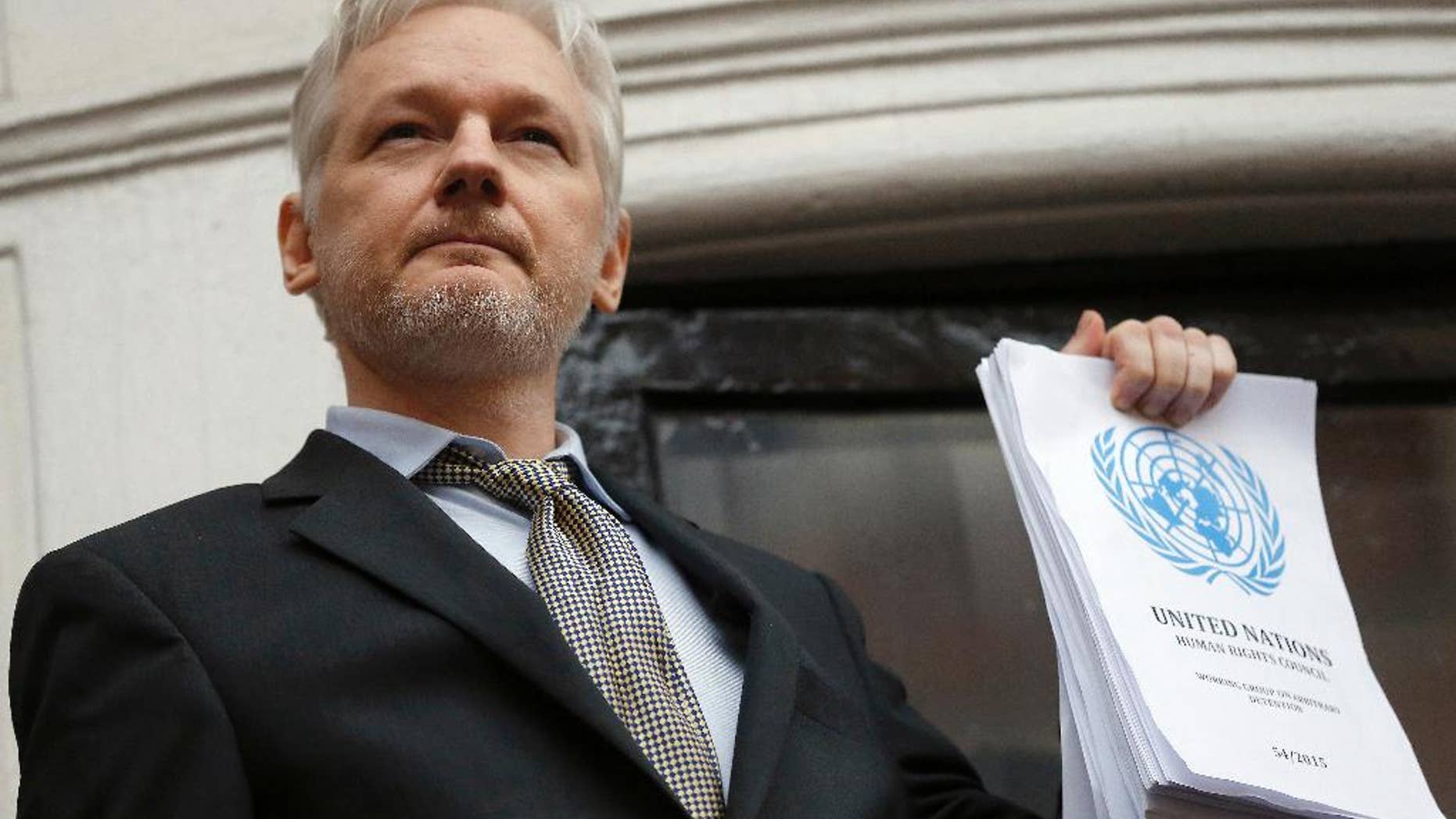 FILE - This is a Friday, Feb. 5, 2016 file photo of WikiLeaks founder Julian Assange holds a U.N. report as he speaks on the balcony of the Ecuadorian Embassy in London. A U.N. panel is sticking by its opinion that WikiLeaks founder Julian Assange is a victim of arbitrary detention, rejecting a request by Britain to review the case. The Working Group on Arbitrary Detention found that Britain had not presented enough new information to merit a new examination. The panel made the decision at a meeting last week, the U.N. human rights office said Wednesday, Nov. 30, 2016. (AP Photo/Frank Augstein, File)