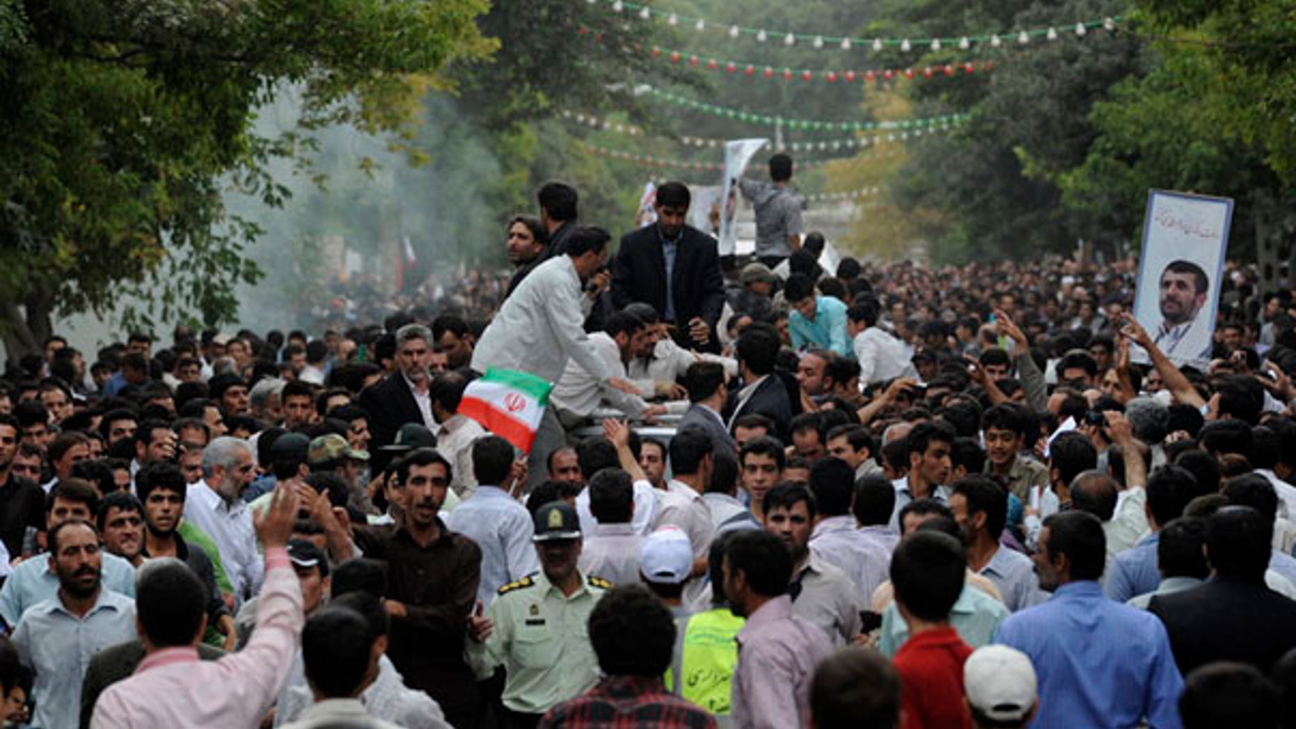 Aug. 4: Smoke rises next to a vehicle transporting Iranian President Mahmoud Ahmadinejad, center, as he arrives in the city of Hamedan, 200 miles southwest of the capital Tehran. A homemade grenade reportedly exploded in Hamedan near Ahmadinejad's convoy in an apparent assassination attempt, though Tehran state TV denied the report.