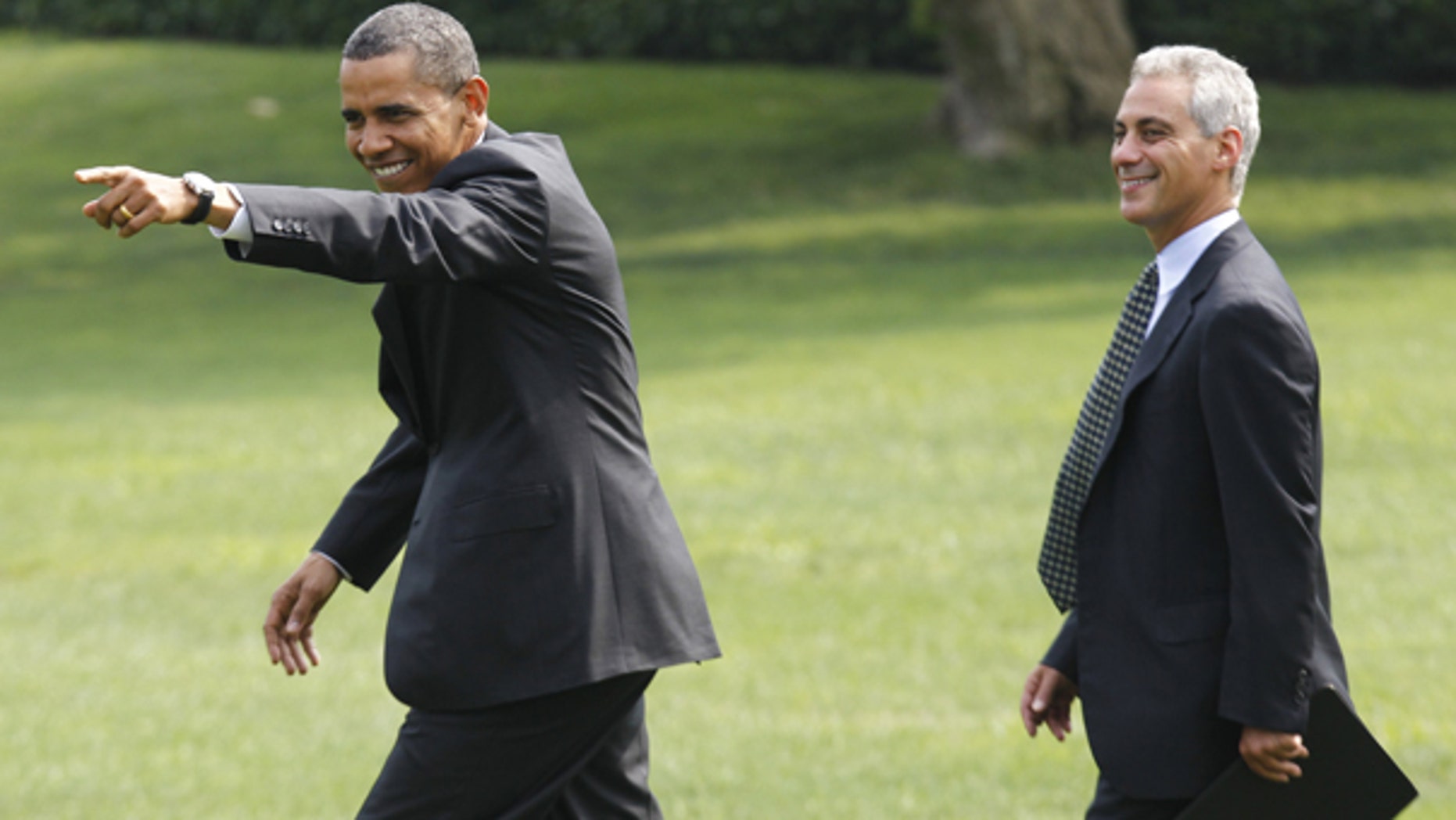 Aug 4: President Barack Obama points to visitors singing "Happy Birthday" to him as he walks with White House chief of staff Rahm Emanuel towards Marine One helicopter on the South Lawn of the White House.