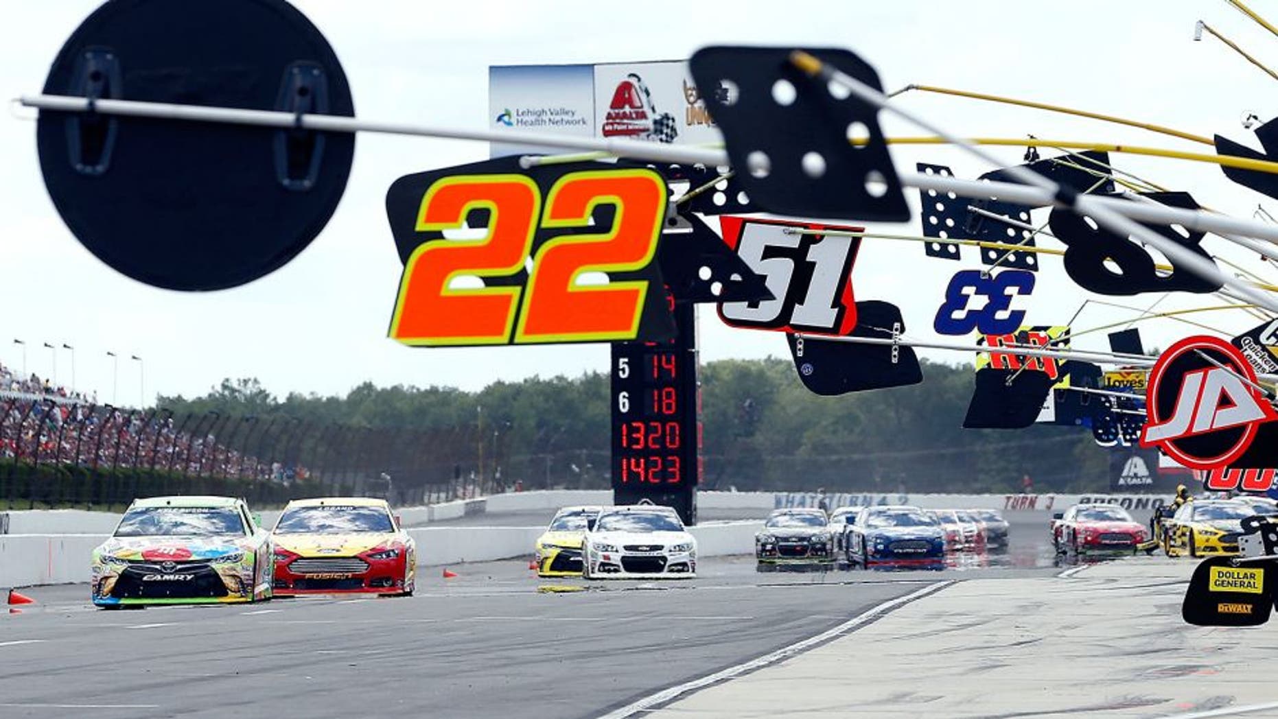 LONG POND, PA - AUGUST 02: Kyle Busch, driver of the #18 M&M's Crispy Toyota, leads a pack of cars onto pit road during the NASCAR Sprint Cup Series Windows 10 400 at Pocono Raceway on August 2, 2015 in Long Pond, Pennsylvania. (Photo by Jeff Zelevansky/NASCAR via Getty Images)