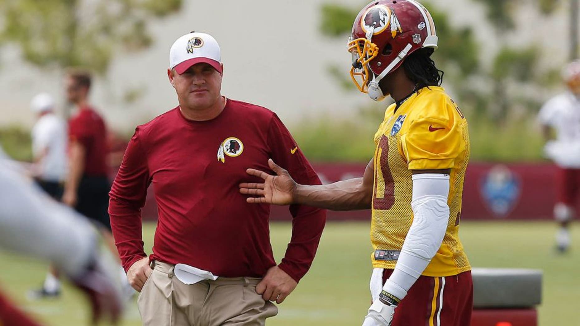 Jul 30, 2015; Richmond, VA, USA; Washington Redskins head coach Jay Gruden (L) talks with Redskins quarterback Robert Griffin III (10) during afternoon practice on day one of training camp at the Washington Redskins Bon Secours Training Center. Mandatory Credit: Geoff Burke-USA TODAY Sports
