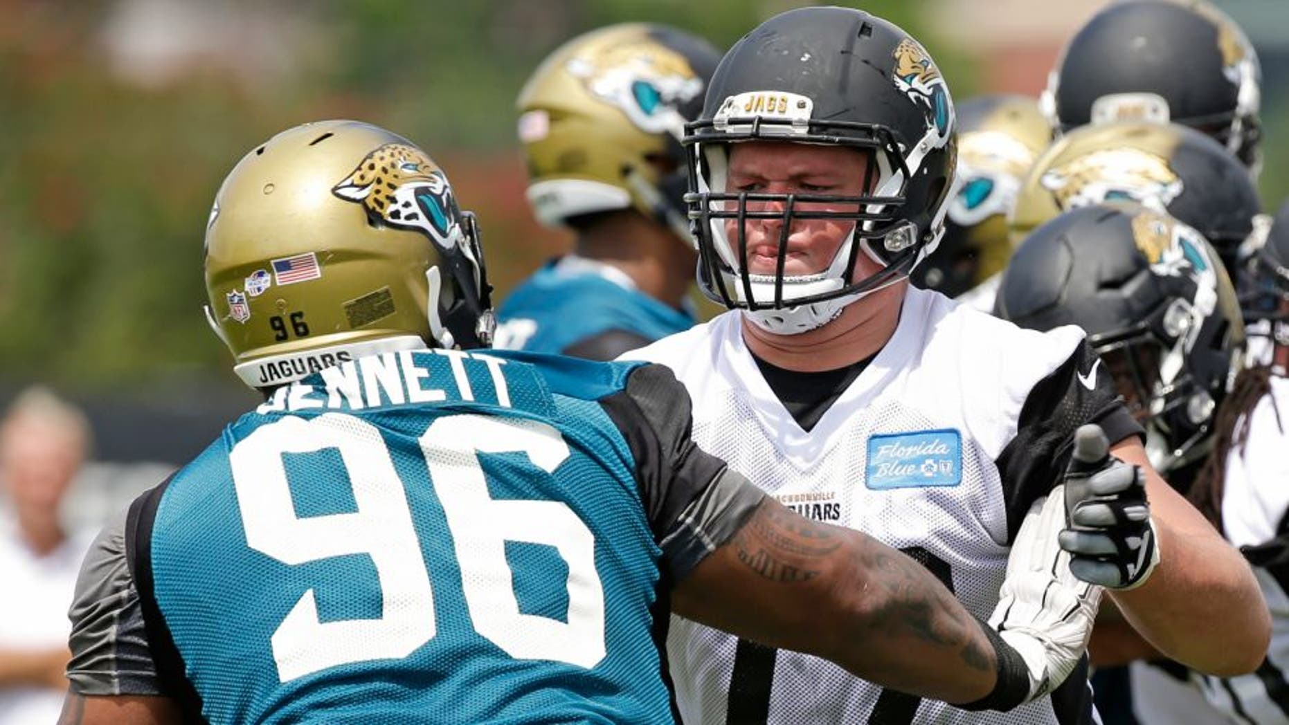 Jacksonville Jaguars tackle Josh Wells (72) blocks defensive tackle Michael Bennett (96) during a light scrimmage at NFL football training camp, Friday, July 31, 2015, in Jacksonville, Fla. (AP Photo/John Raoux)