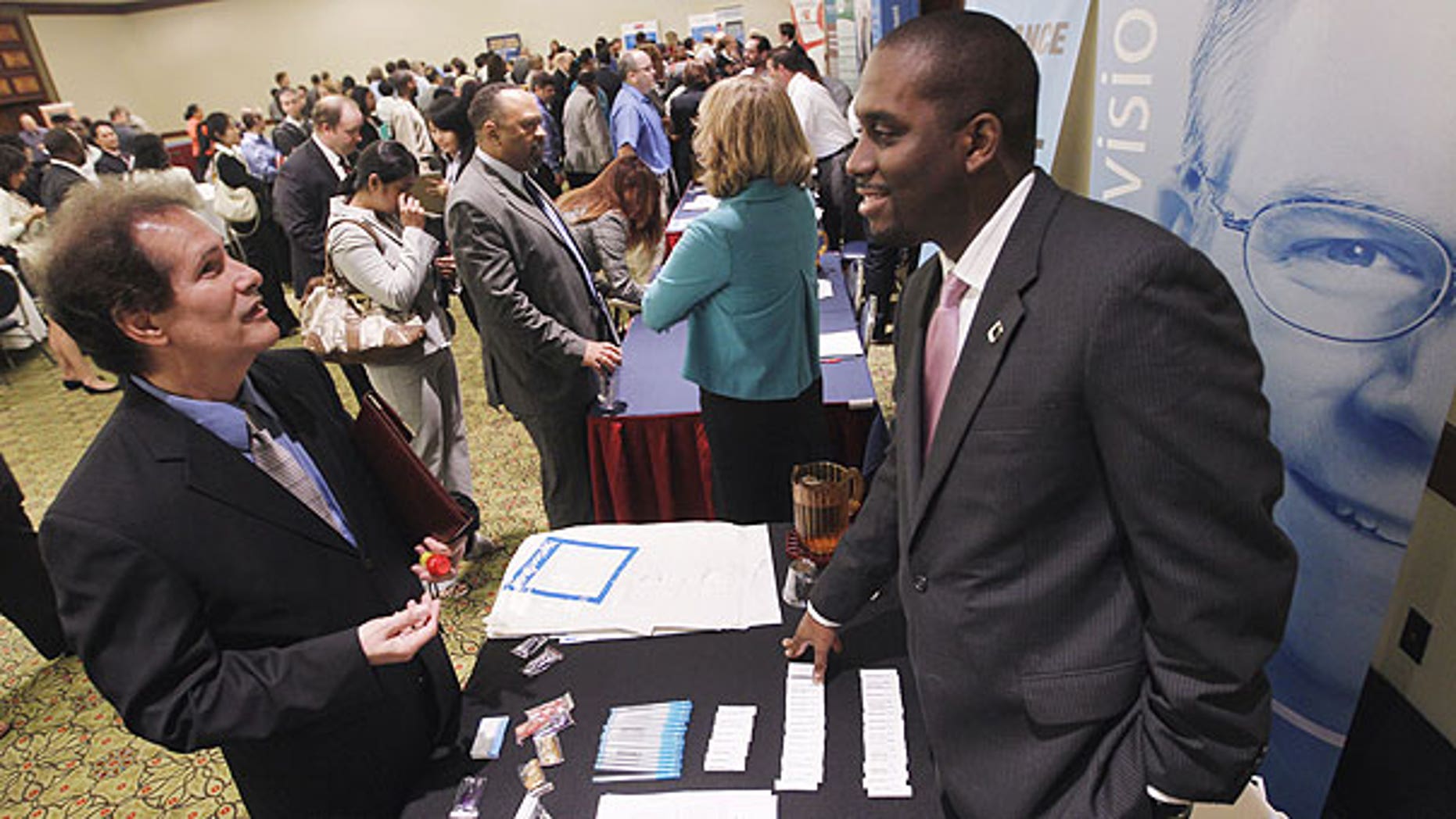 Aug. 4: Recruiter Jason Bryant, right, speaks with job seeker Brian Shumate at the Career Job Fair in Arlington, Va.