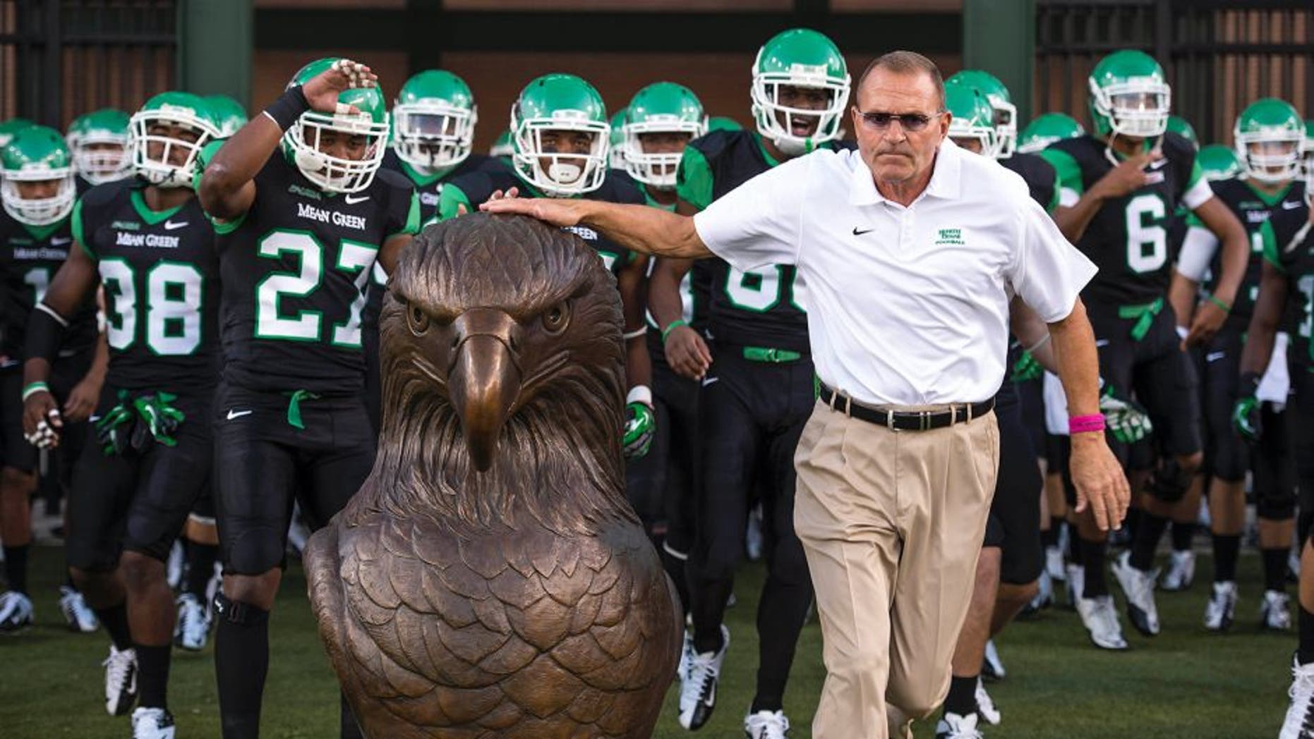 Oct 31, 2013; Denton, TX, USA; North Texas Mean Green head coach Dan McCarney leads his team on the field to face the Rice Owls at Apogee Stadium. The Mean Green defeated the Owls 28-16. Mandatory Credit: Jerome Miron-USA TODAY Sports