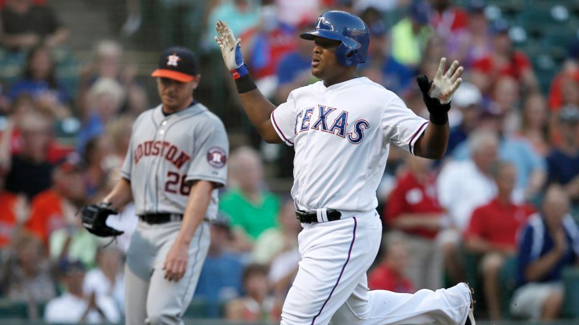 Texas Rangers' Adrian Beltre celebrates after crossing the plate, scoring on a Elvis Andrus single off of Houston Astros' Scott Kazmir, rear, in the first inning of a baseball game, Wednesday Aug. 5, 2015, in Arlington, Texas. (AP Photo/Tony Gutierrez)