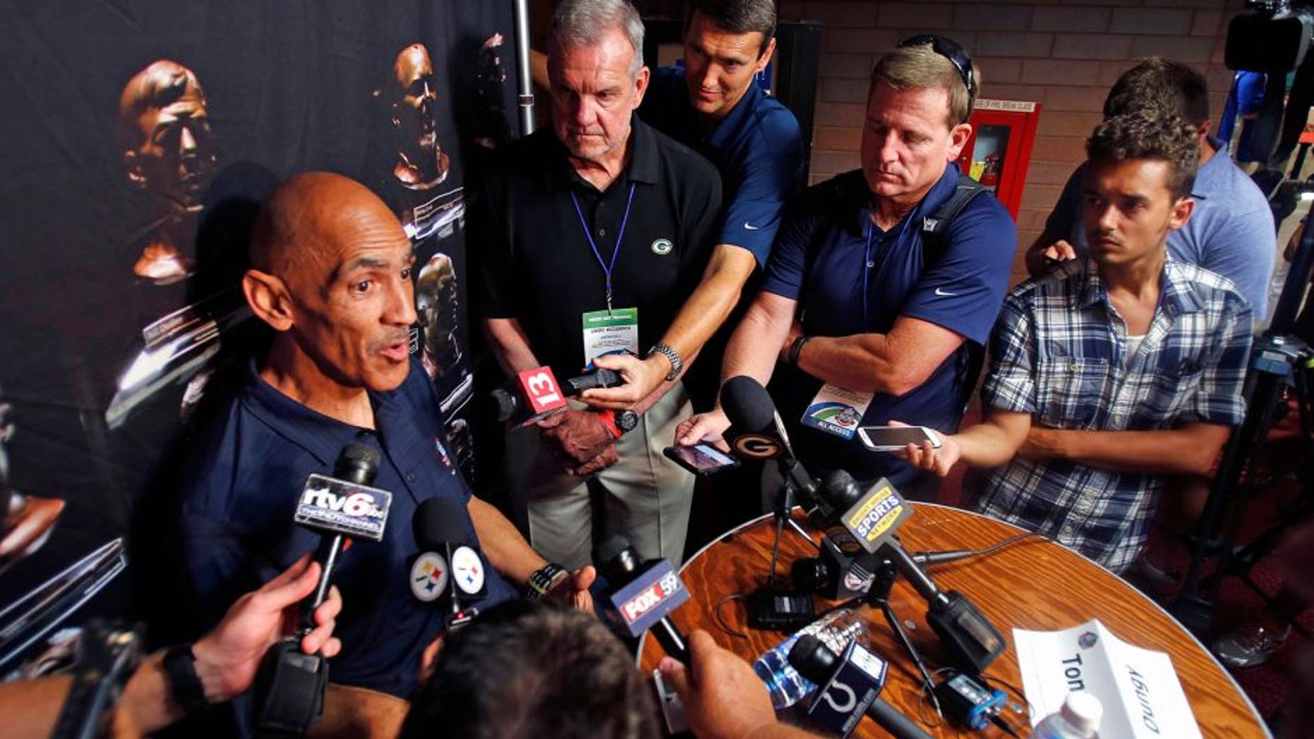 Pro Football Hall of Fame 2016 inductee Tony Dungy, left, talks with reporters Friday, Aug. 5, 2016, in Canton, Ohio. (AP Photo/Gene J. Puskar)