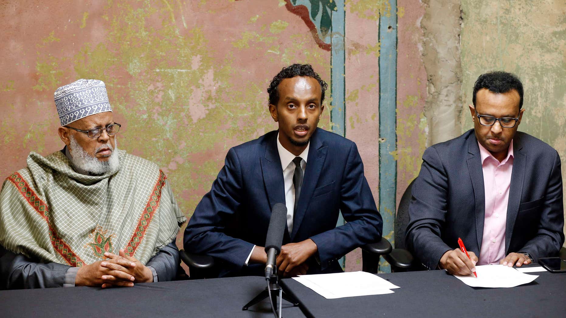 Aug. 6, 2015: Imam Sheikh Sa’ad Musse Roble, left, and Jibril Afyare, right, listen as Abdimalik Mohamed, chairman, addresses a news conference outlining how their task force is working with the U.S. Attorney on a pilot project designed to combat terror recruiting in Minneapolis.