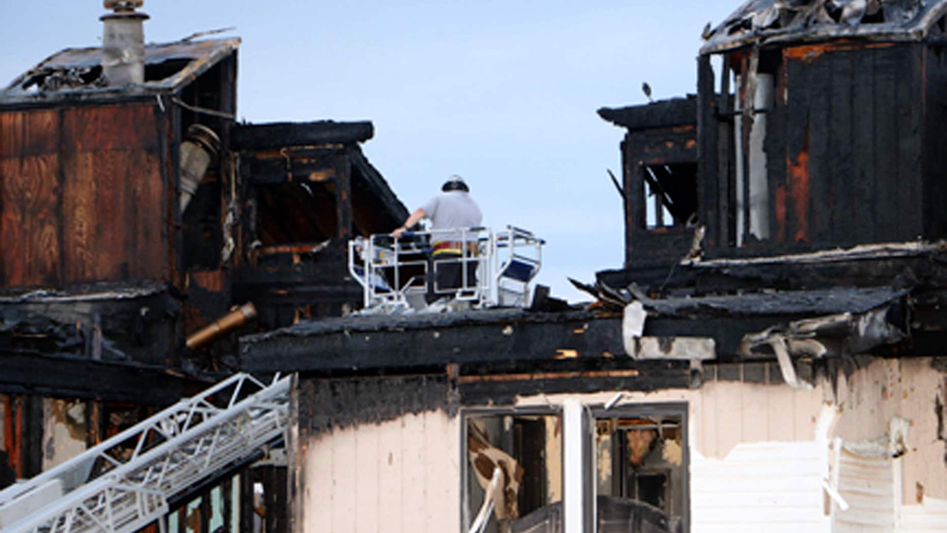 Aug. 5, 2015: In this photo provided by Dan Field, a fire investigator surveys the aftermath of an overnight fire in Osage Beach, Mo.