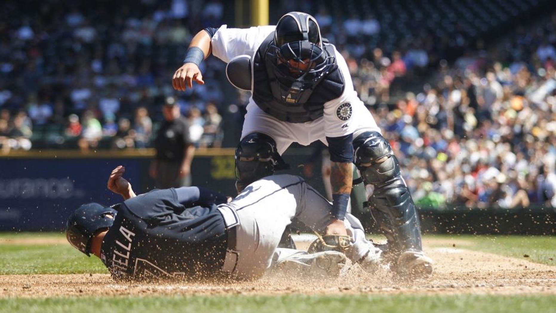 Aug 6, 2014; Seattle, WA, USA; Seattle Mariners catcher Jesus Sucre (2) blocks Atlanta Braves second baseman Tommy La Stella (7) from scoring a run during the third inning at Safeco Field. Mandatory Credit: Joe Nicholson-USA TODAY Sports