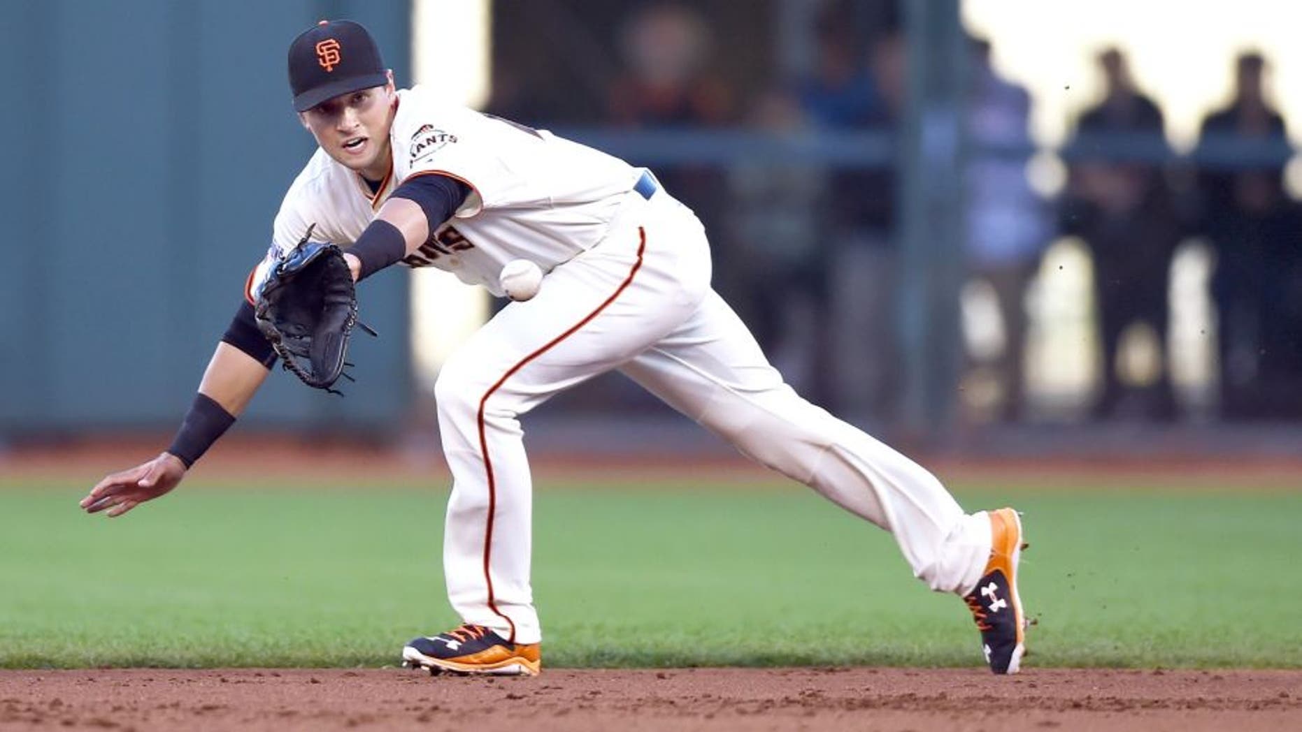 SAN FRANCISCO, CA - JULY 27: Joe Panik #12 of the San Francisco Giants goes up the middle to his backhand to take a hit away from Shane Peterson #35 of the Milwaukee Brewers in the top of the second inning at AT&T Park on July 27, 2015 in San Francisco, California. (Photo by Thearon W. Henderson/Getty Images)