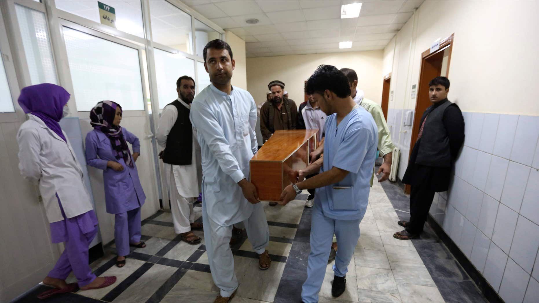 Aug. 7, 2015: Hospital workers carry the dead body of a victim in a car bomb attack in Kabul, Afghanistan.