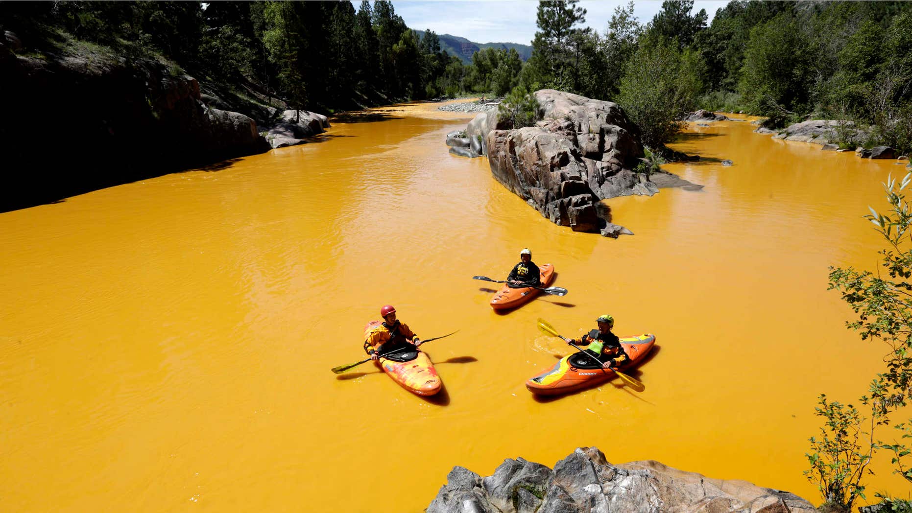 Aug. 6, 2015: People kayak in the Animas River near Durango, Colo. in water colored from a mine waste spill.