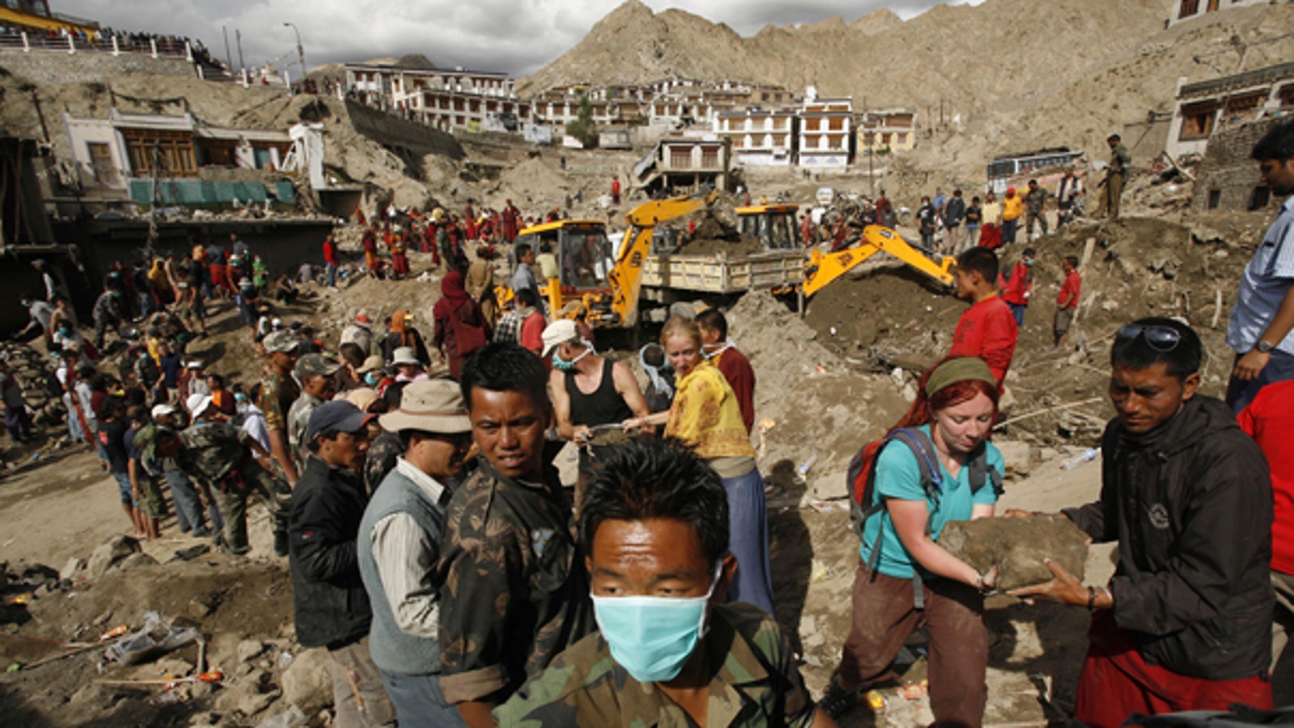 Aug. 7: Foreign tourists assist locals in removing debris from a flash flood-affected area of Leh, India. Authorities stepped up rescue efforts as the weather improved Saturday, a day after flash floods sent rivers of mud down desert mountainsides in Indian-controlled Kashmir, killing scores of people and injuring hundreds, officials said.