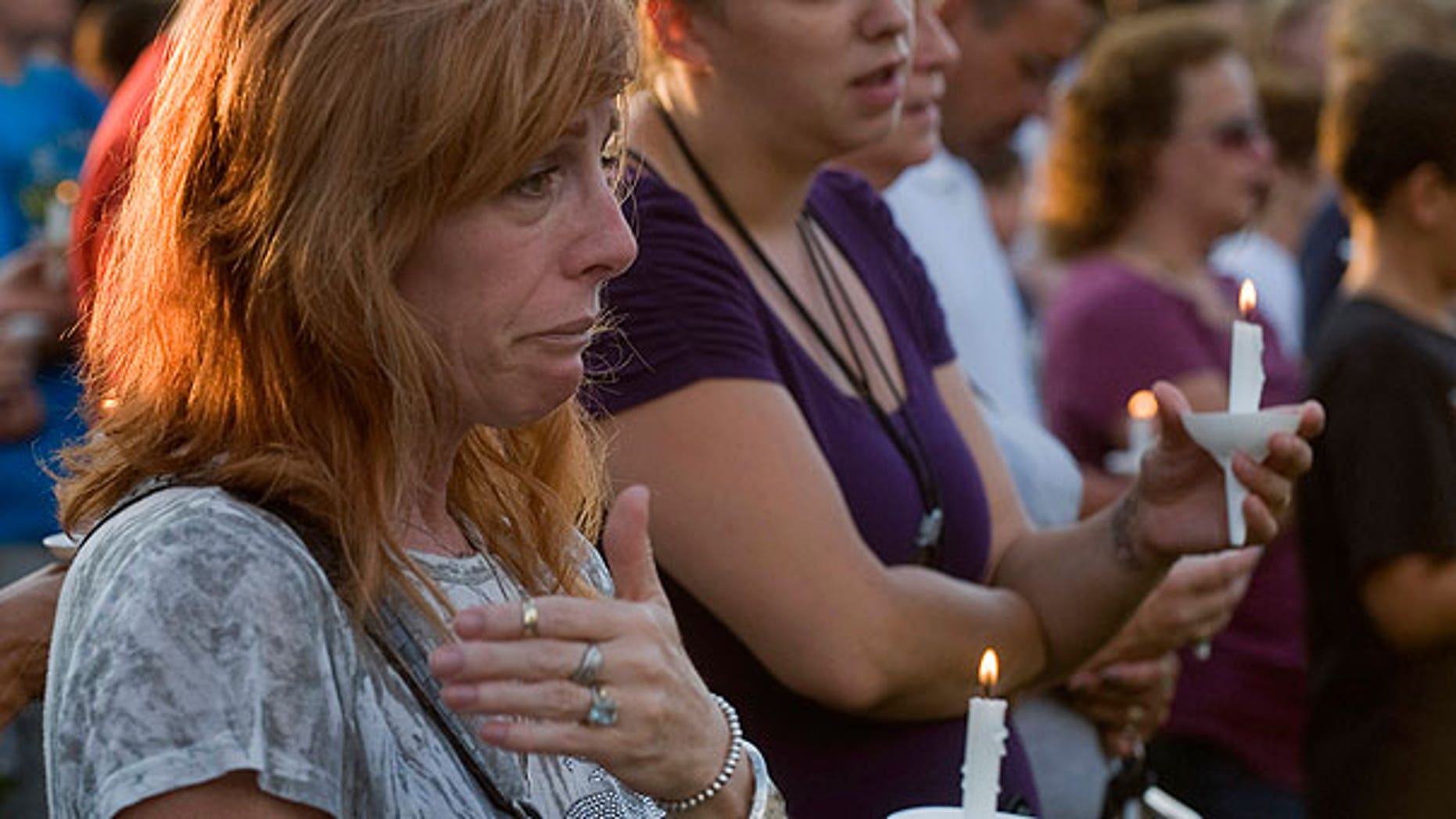 Aug. 7: Bambi Lynn of Fairlawn, Ohio, wipes away tears during a prayer vigil at Copley Community Park in Copley Township, Ohio.