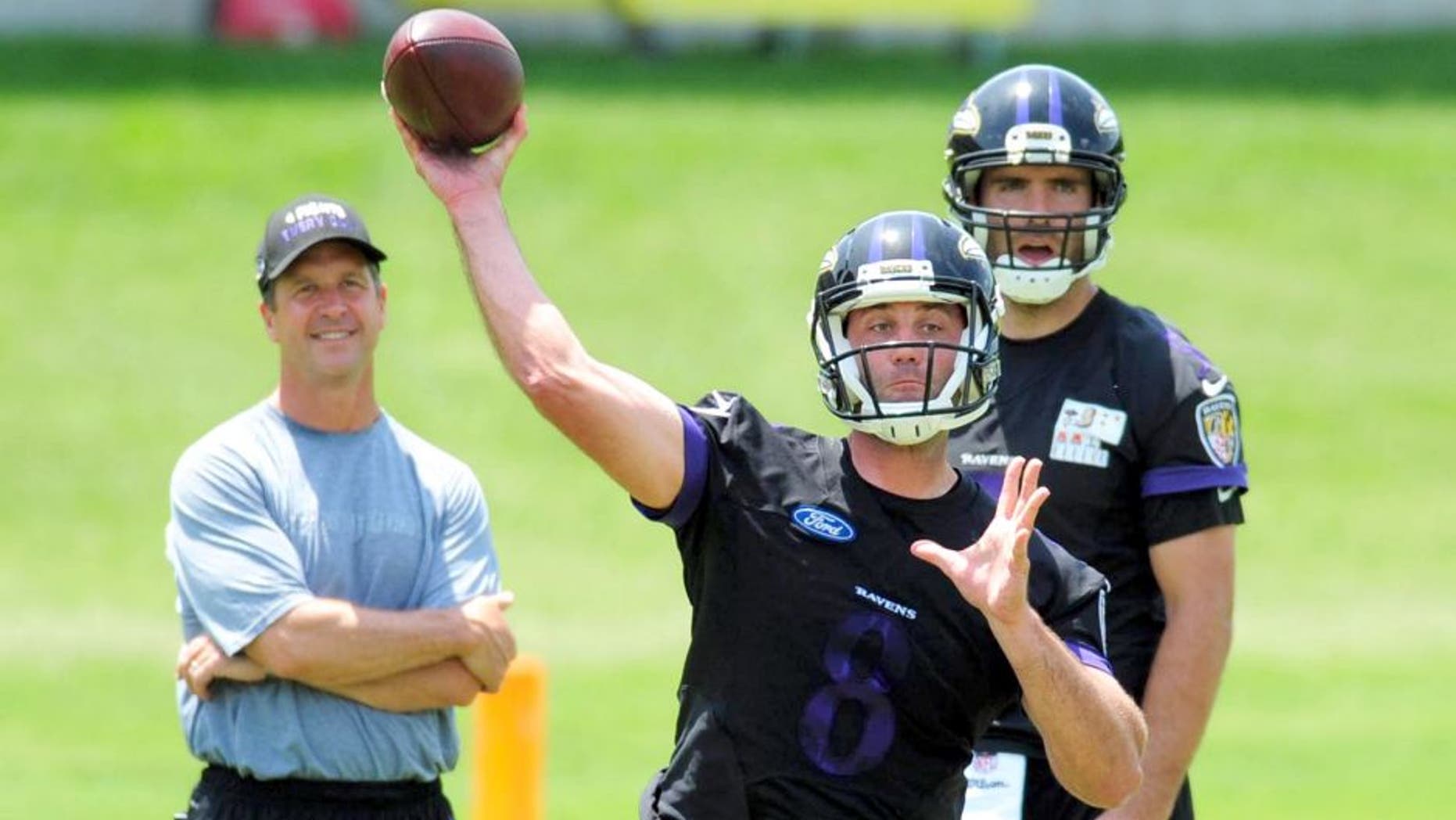 May 28, 2015; Baltimore, MD, USA; Baltimore Ravens quarterback Matt Schaub (center) throws a pass as head coach John Harbaugh (left) and quarterback Joe Flacco (right) look on during training camp at the Under Armour Performance Center. Mandatory Credit: Evan Habeeb-USA TODAY Sports